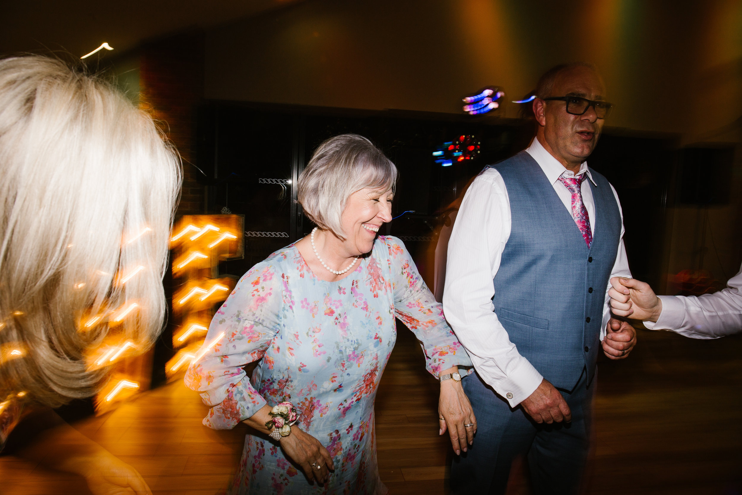 mother of the bride dressed in floral blue dancing on the dance floor after shots