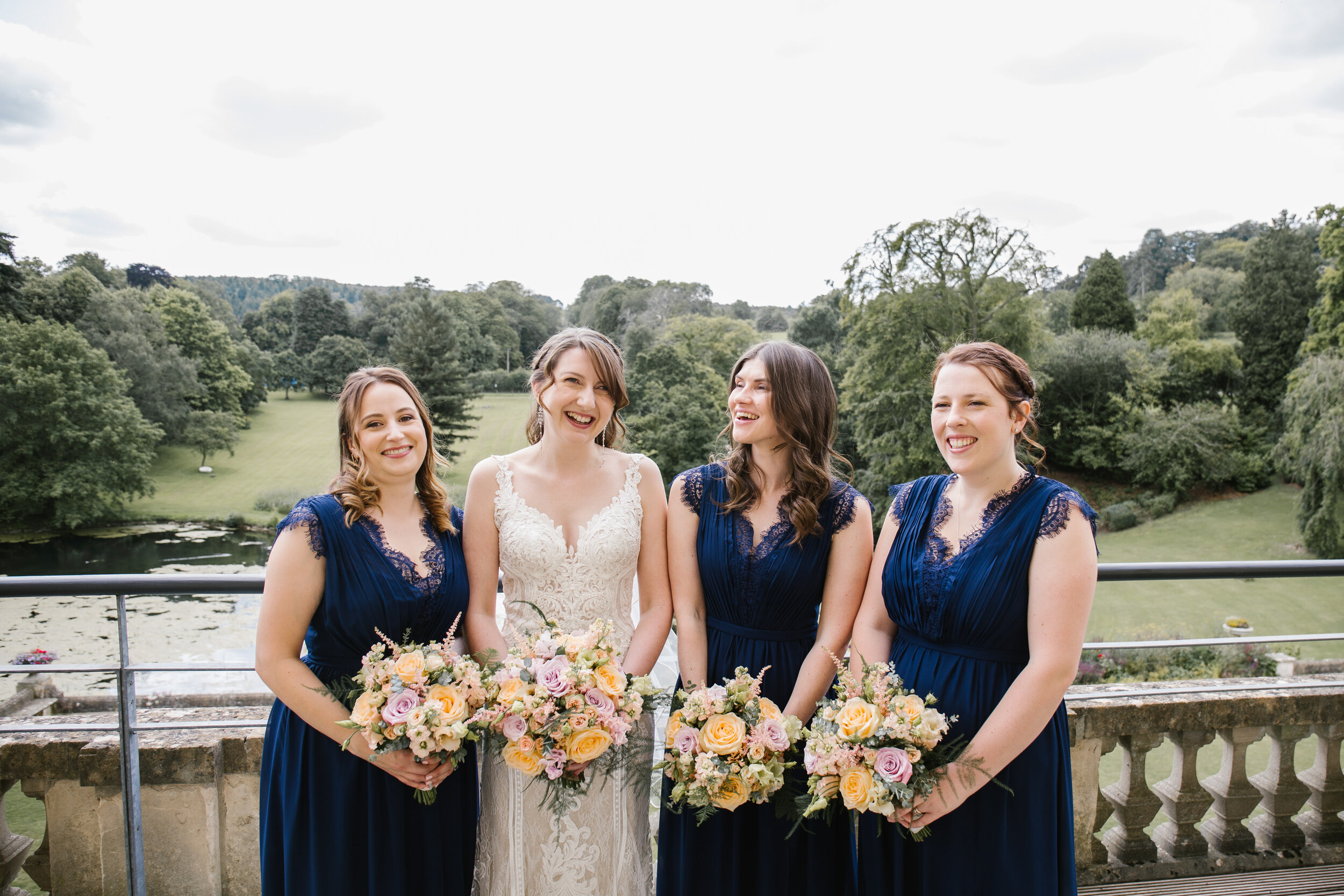 bride with her bridesmaids on the balcony of the bridal suite at cowley manor