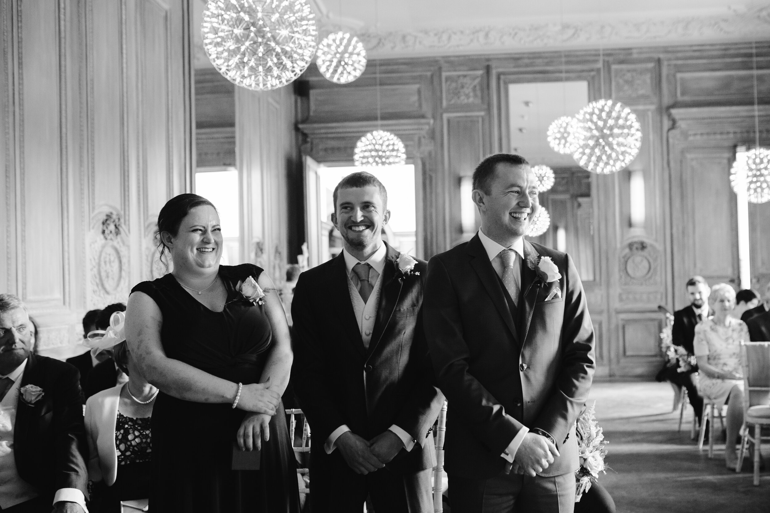 natural black and white photo of the groom with his best men at his wedding ceremony at cowley manor
