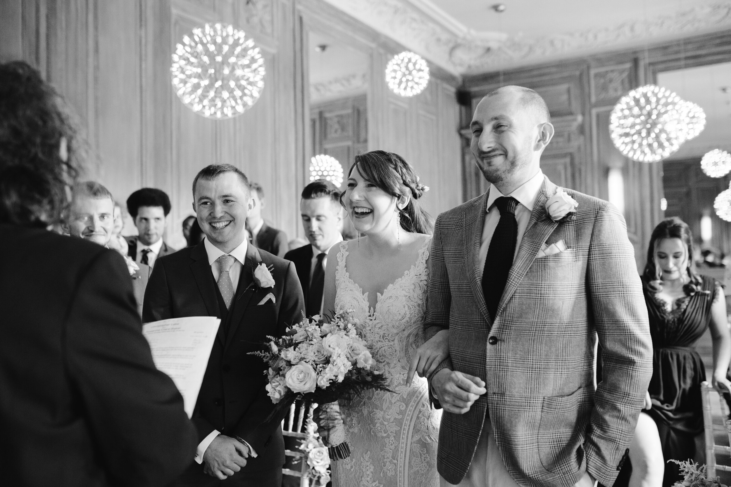 natural happy photo of the bride as she meets her groom at the top of the aisle at cowley manor