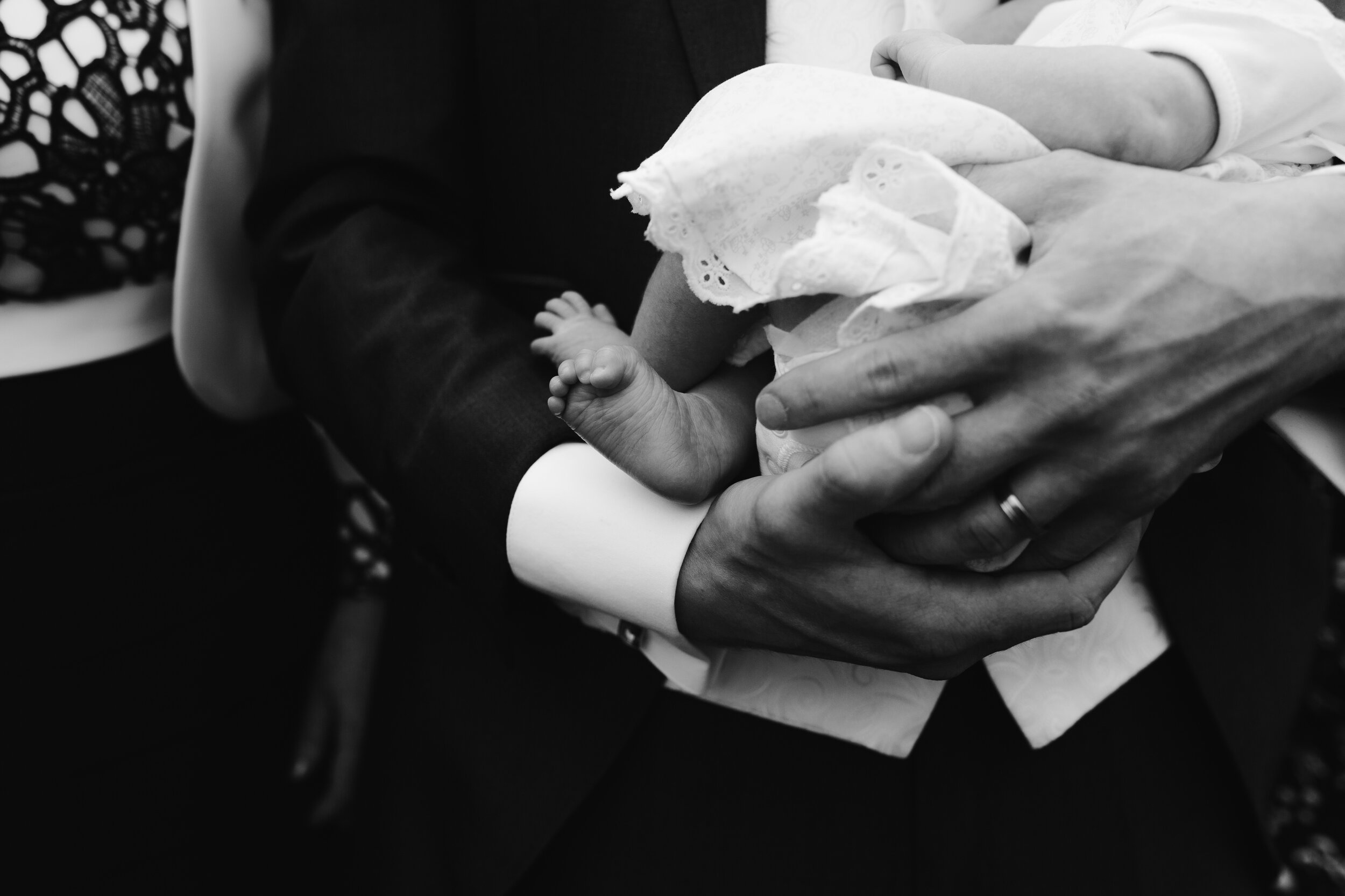 black and white photo of close up of babies feet at a wedding 