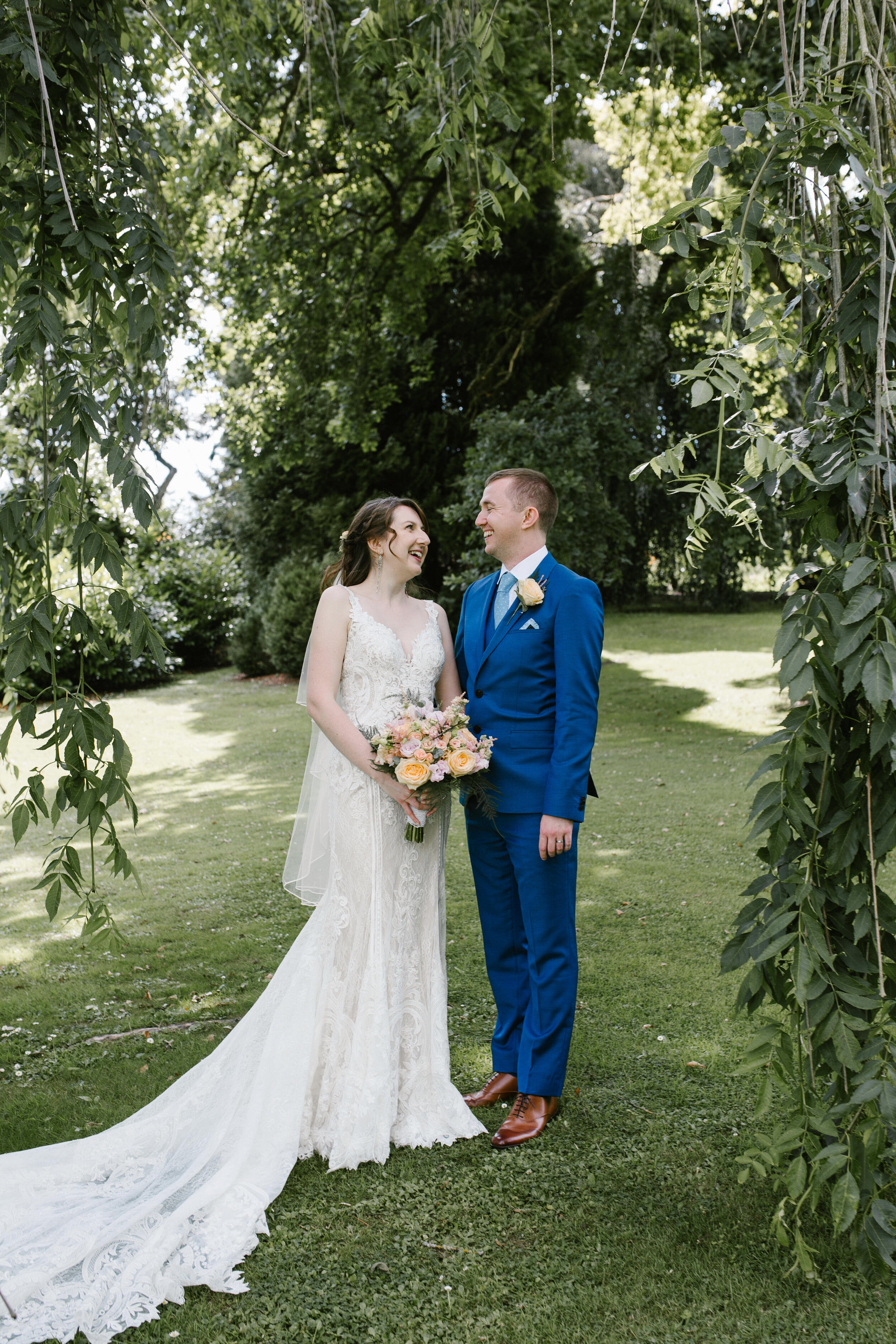 beautifully natural portrait of bride and groom together laughing in the grounds of cowley manor