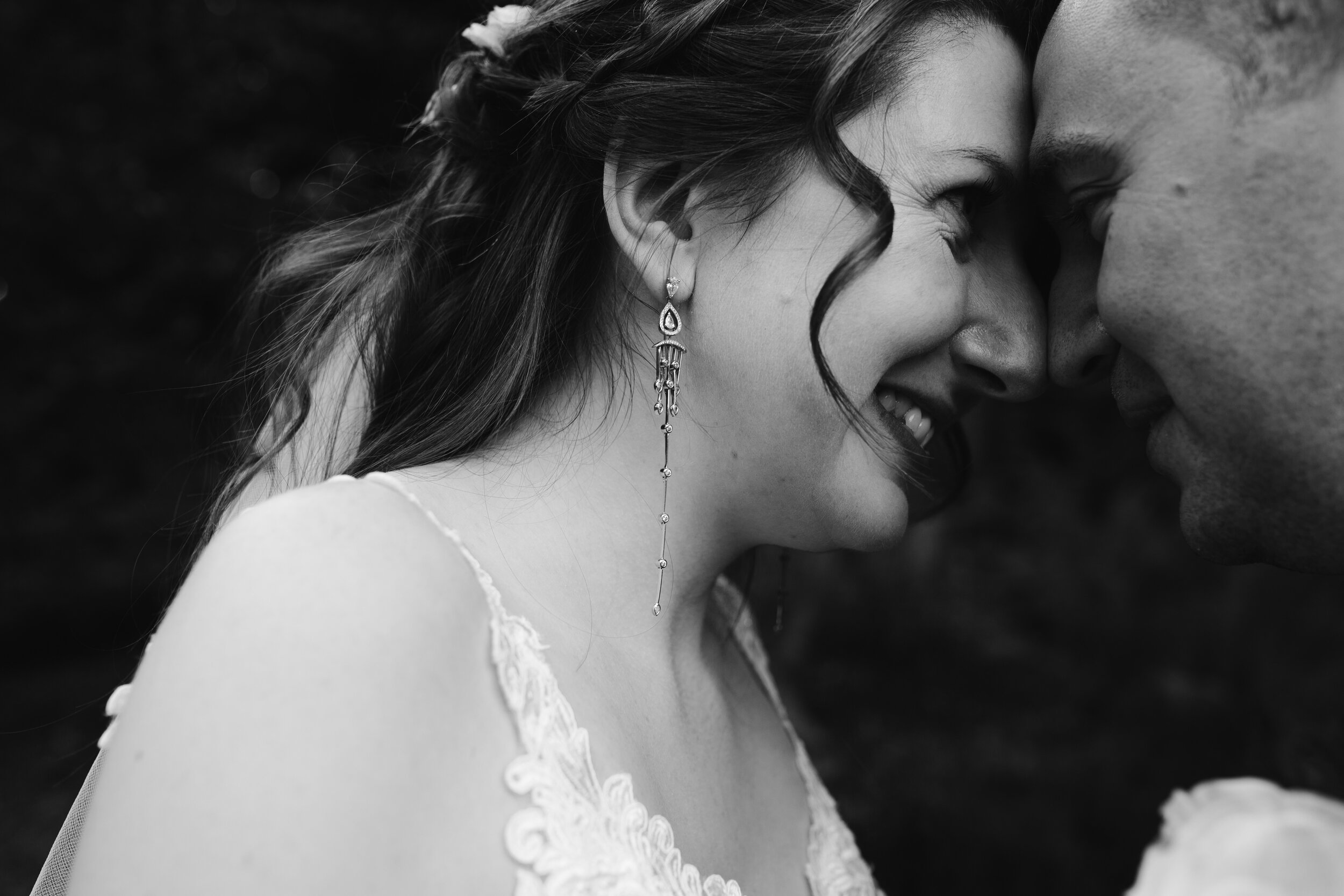 close up black and white photo of bride and groom touching their faces together