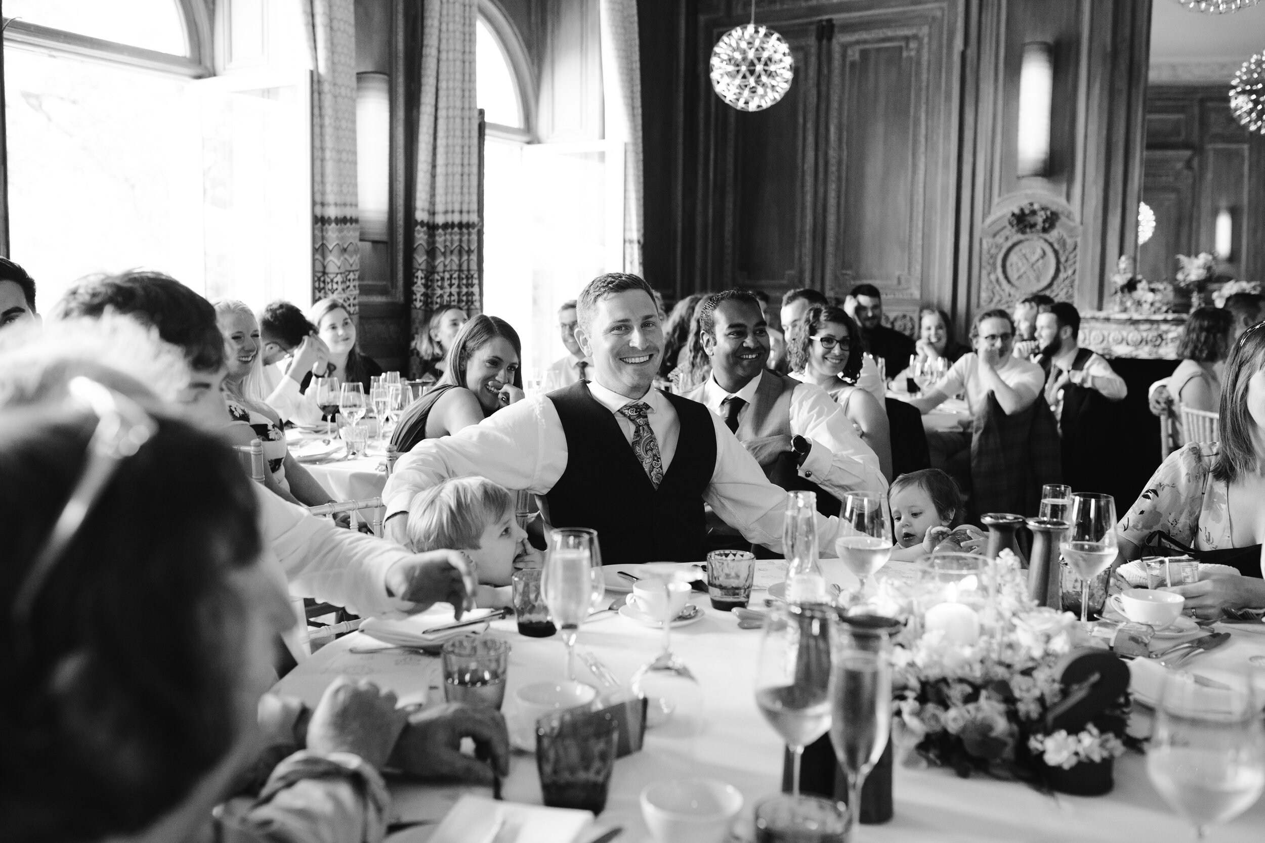 black and white photo of wedding guest laughing at speeches