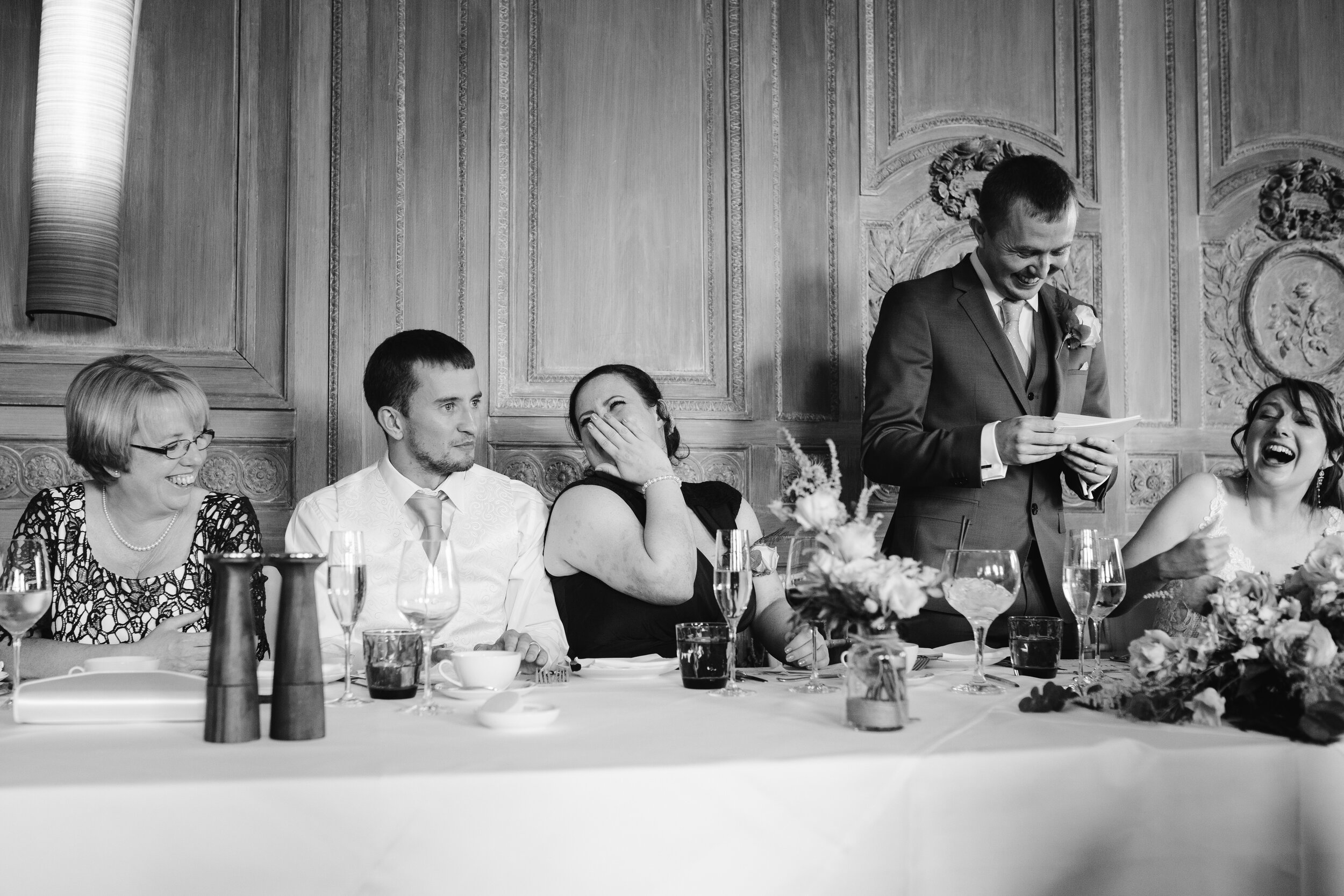 fun photo of the top table laughing during the grooms speech