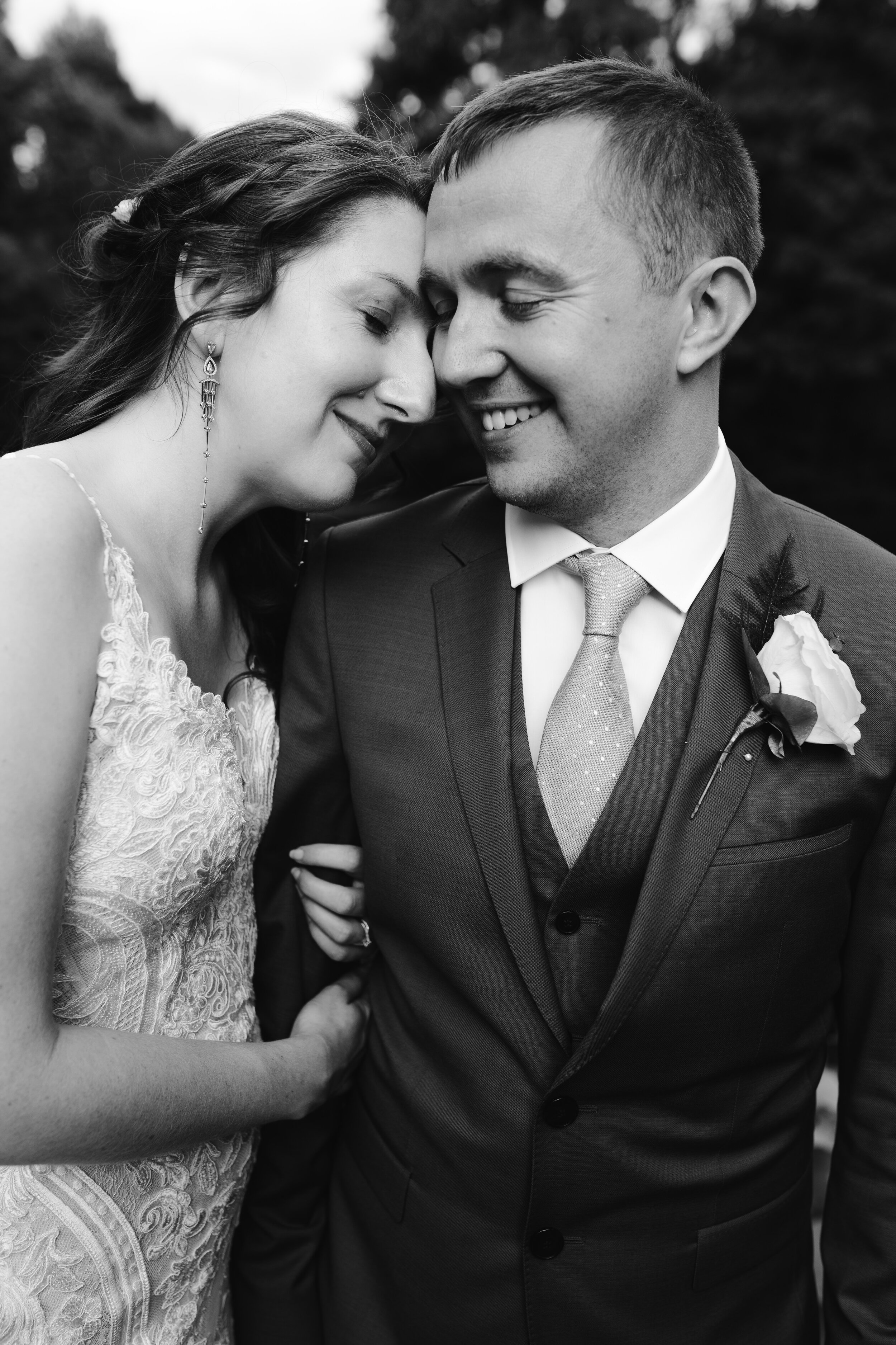 black and white romantic portrait of bride and groom together at cowley manor