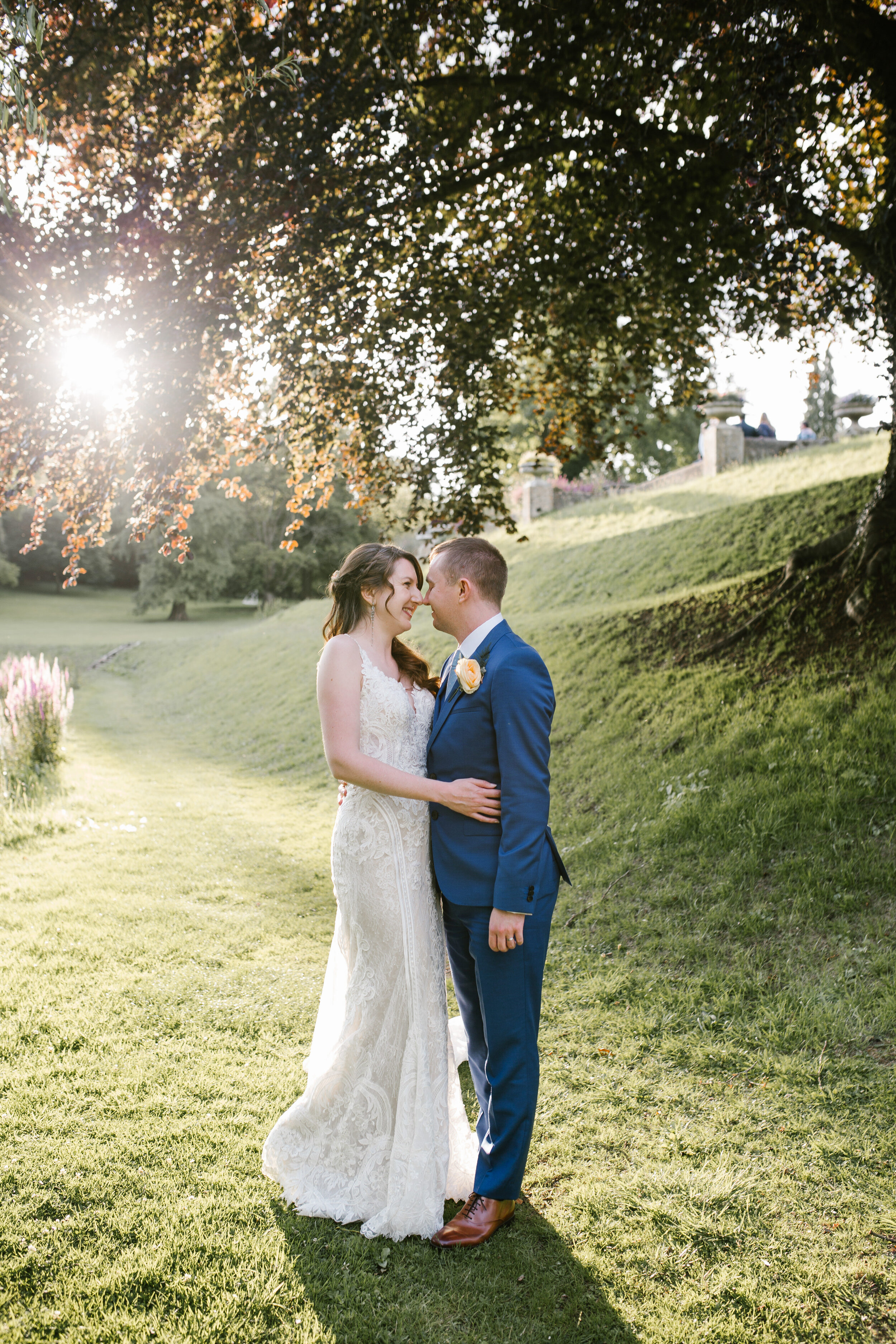 beautiful portarit of bride and groom smiling together in golden hour at cowley manor