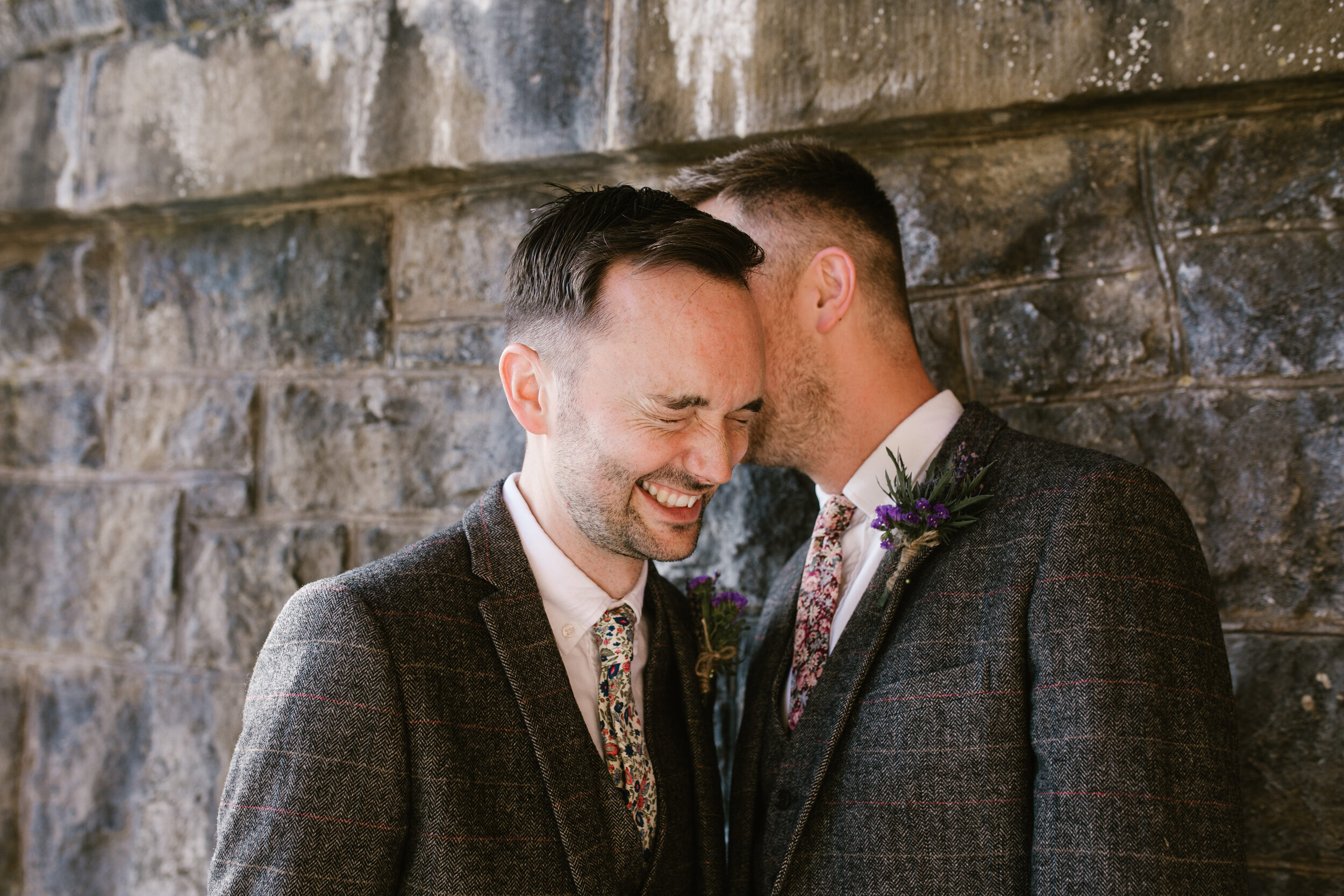 groom whispering into his grooms ear, a fun happy photo