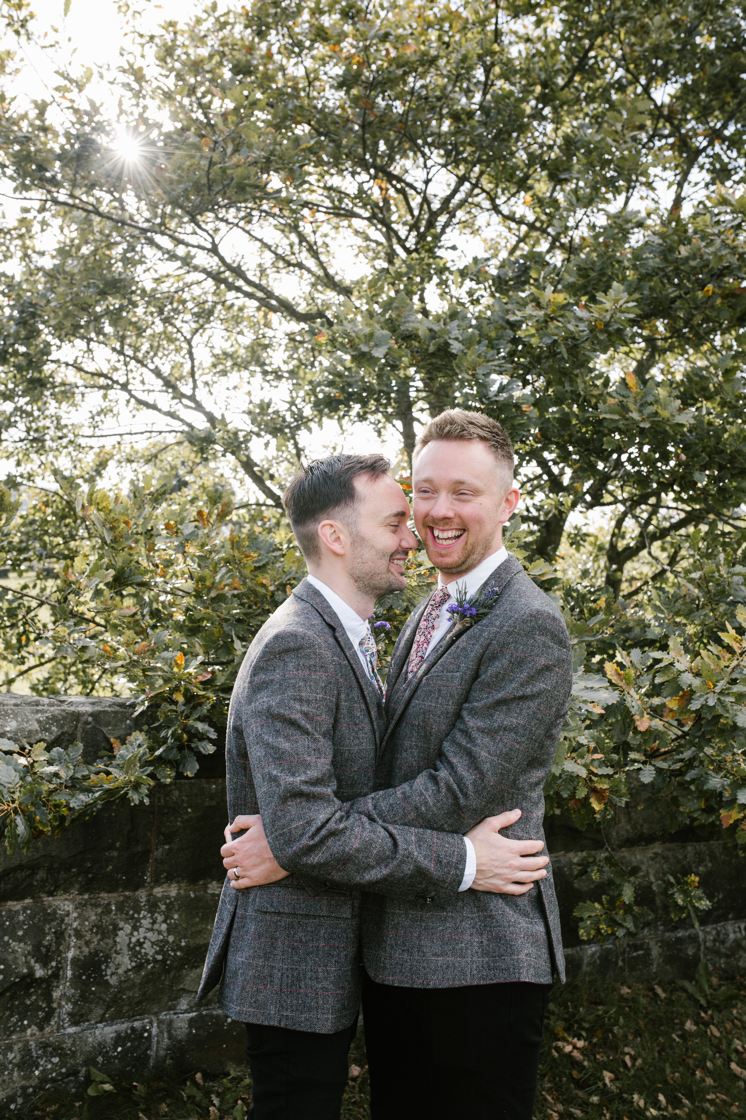 tower hill barns wedding- photo of two grooms hugging together in the golden hour light
