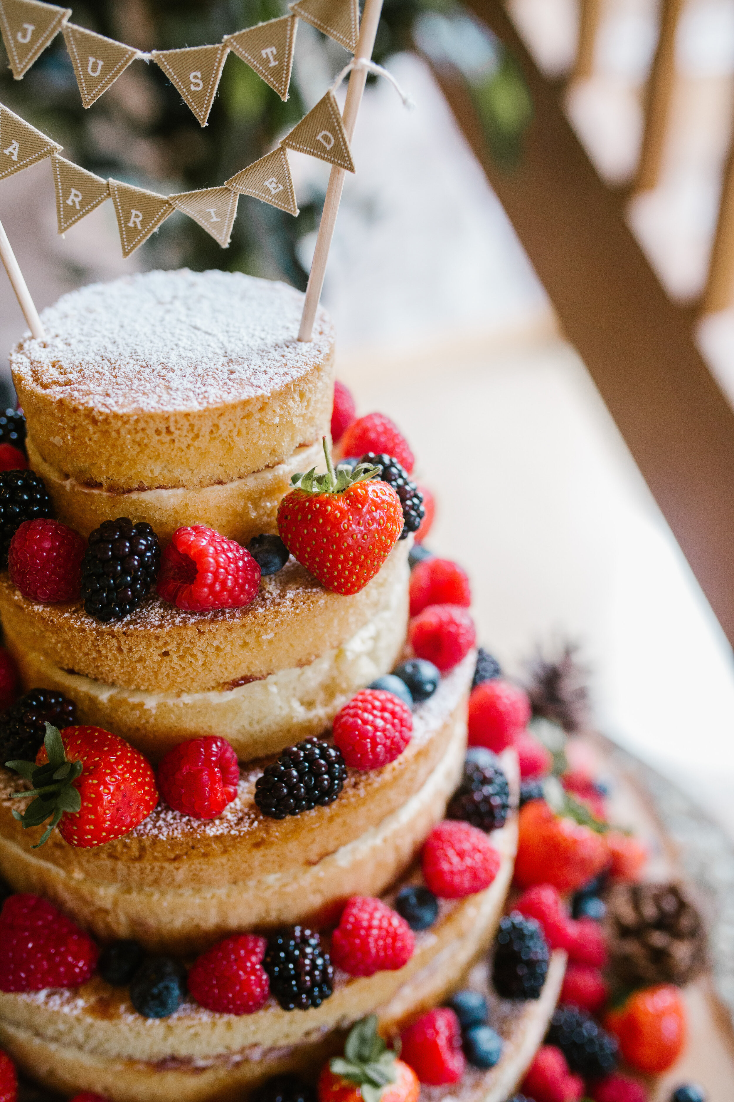 detail shot of wedding cake inspiration of a naked fruit cake of 5 tiers and winter fruits