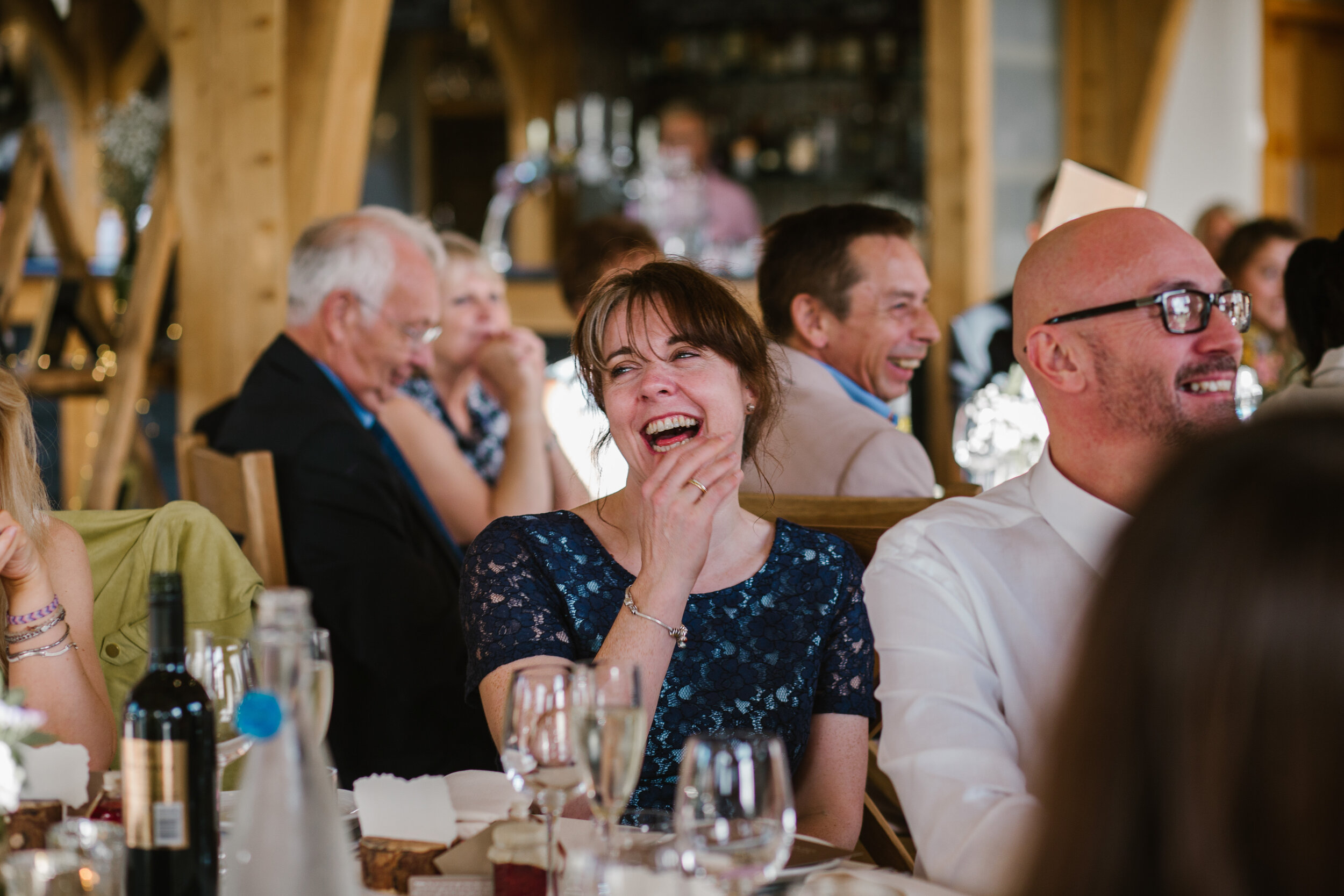 close up photo of guests laughing during the wedding speeches at tower hill barns