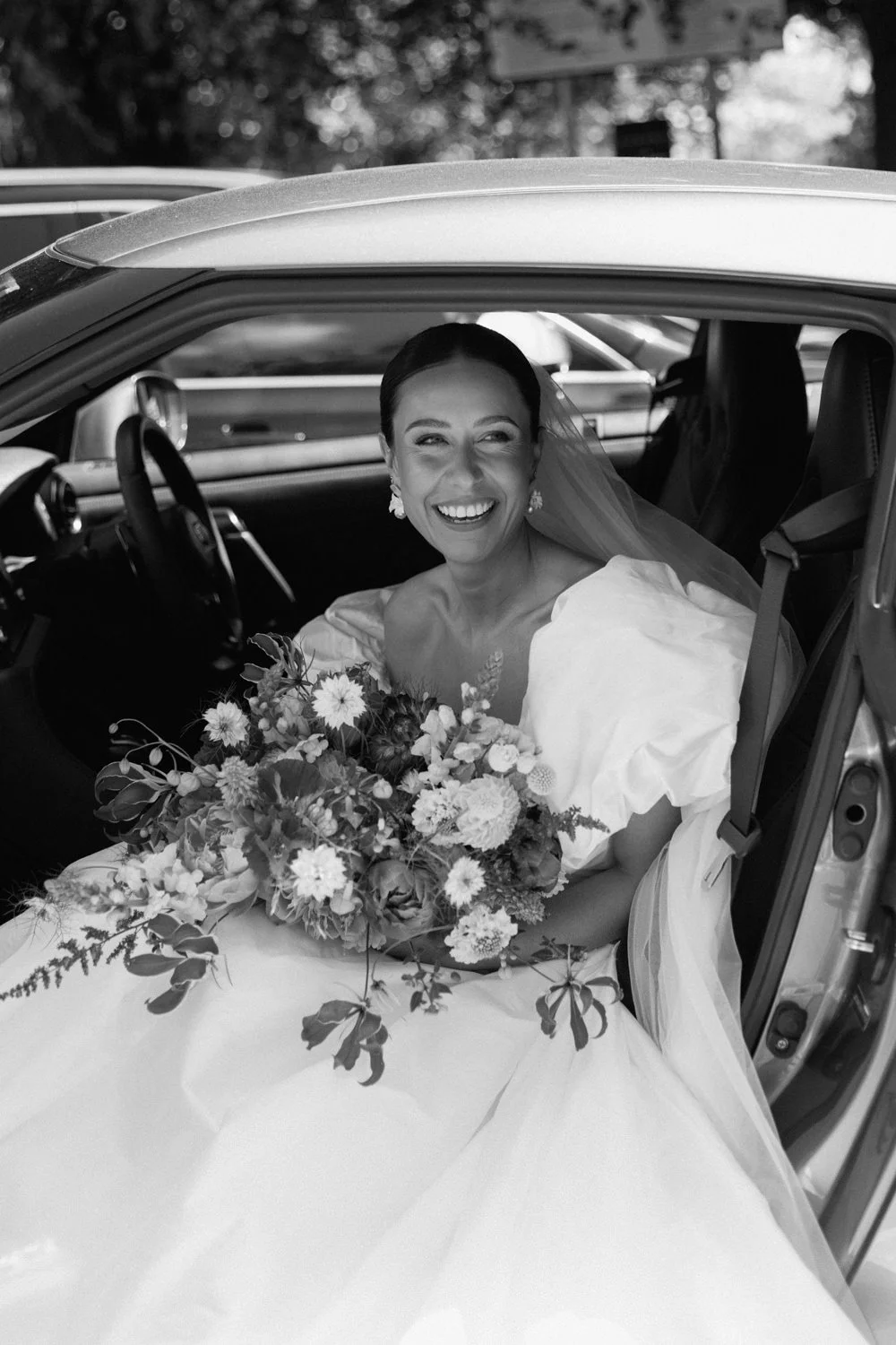 Black and white photo of Bride in car