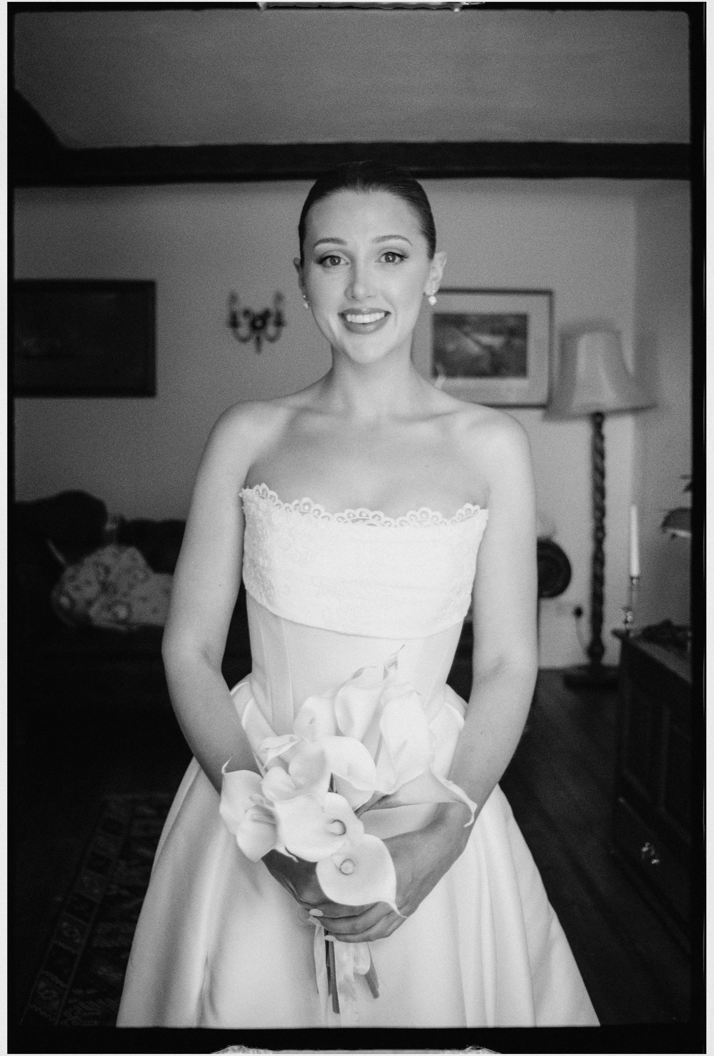 Black and white 35mm photo of a bride smiling at camera
