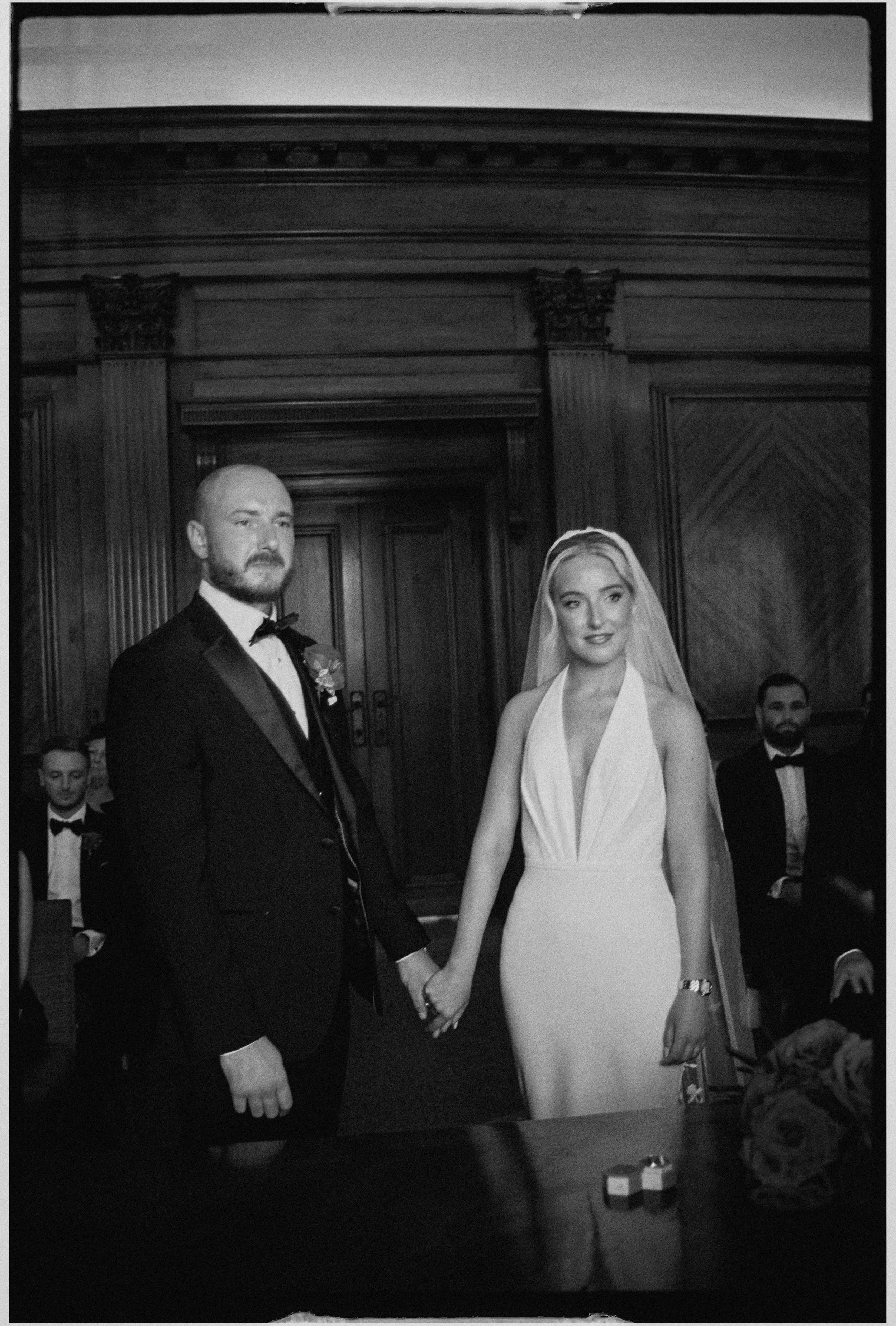 Black and white 35mm photo of bride and groom getting married at Marylebone Town Hall