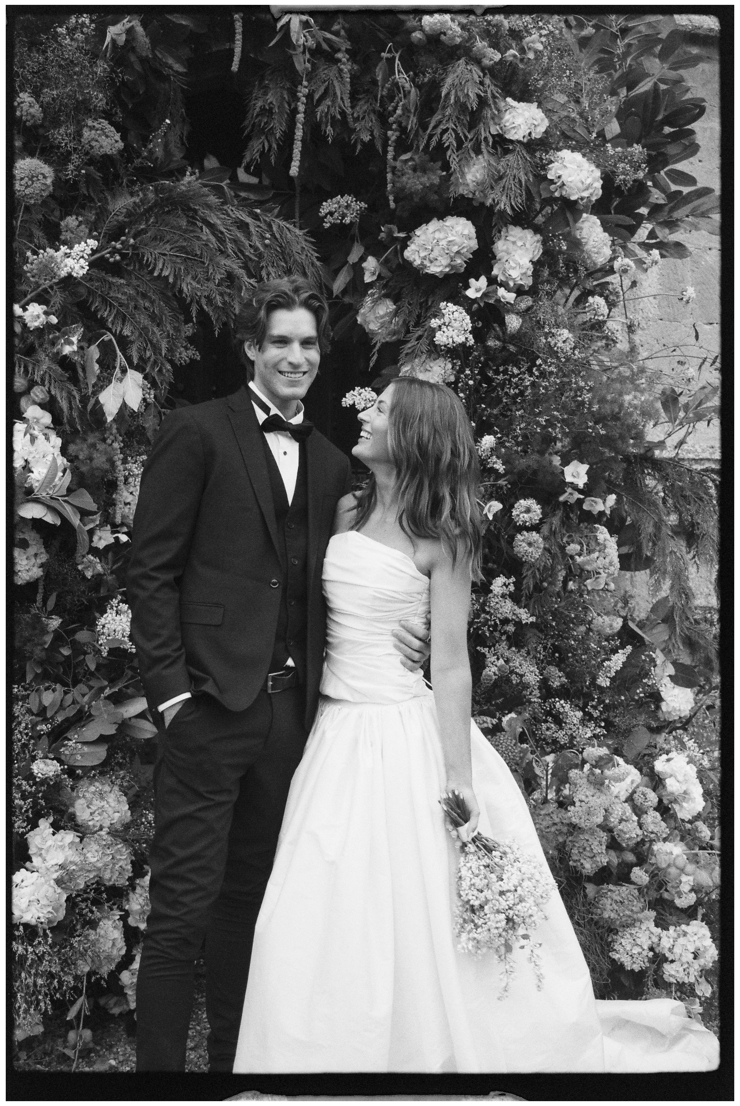 Black and white film photo of bride and groom laughing together at Sudeley Castle