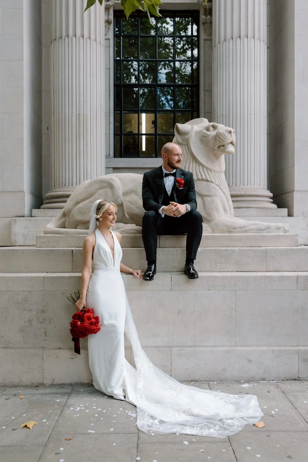 Stylish bride and groom sat by the iconic Lion at Marylebone Town Hall