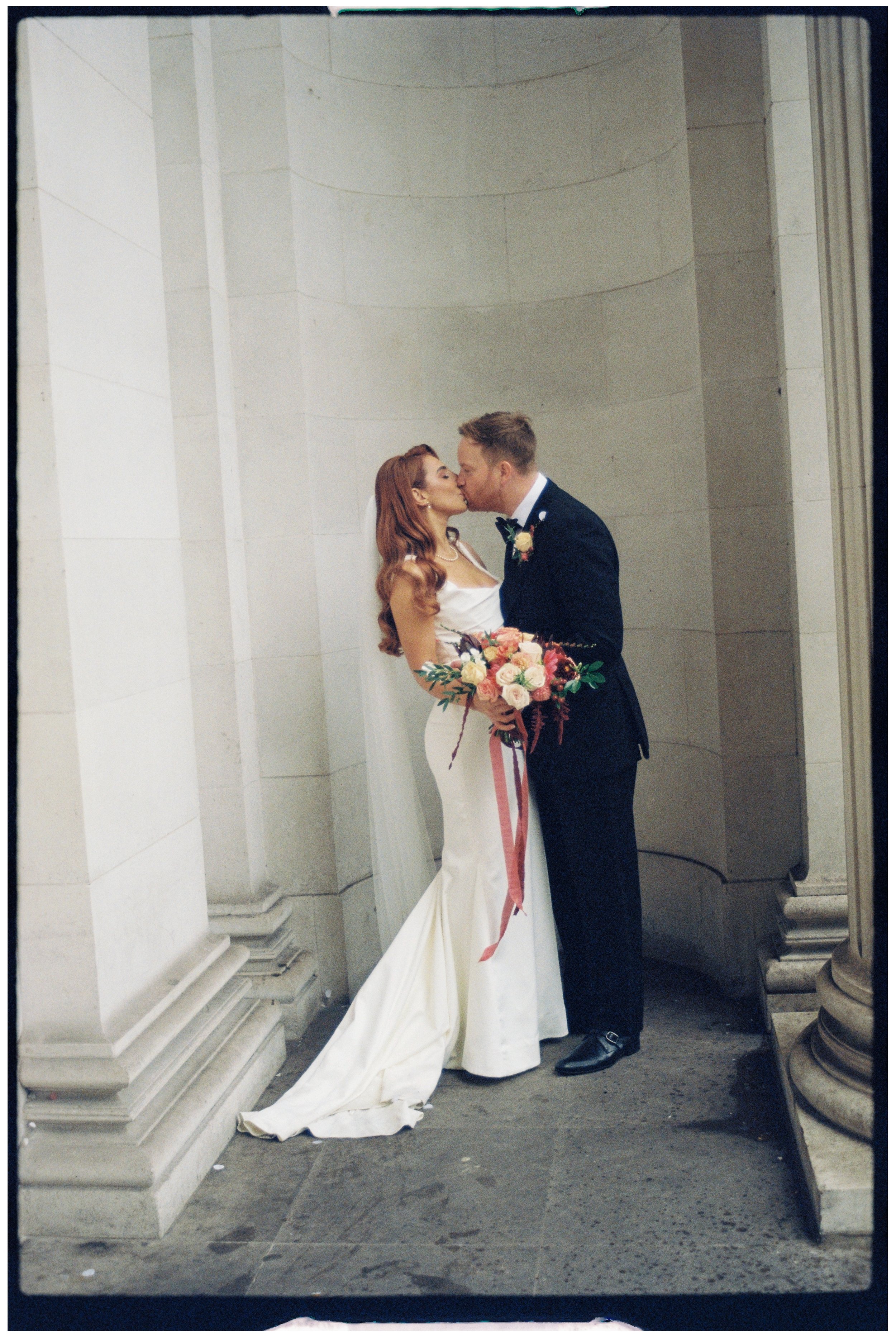 Bride and groom kissing in the alcoves at The Old Marylebone Town Hall