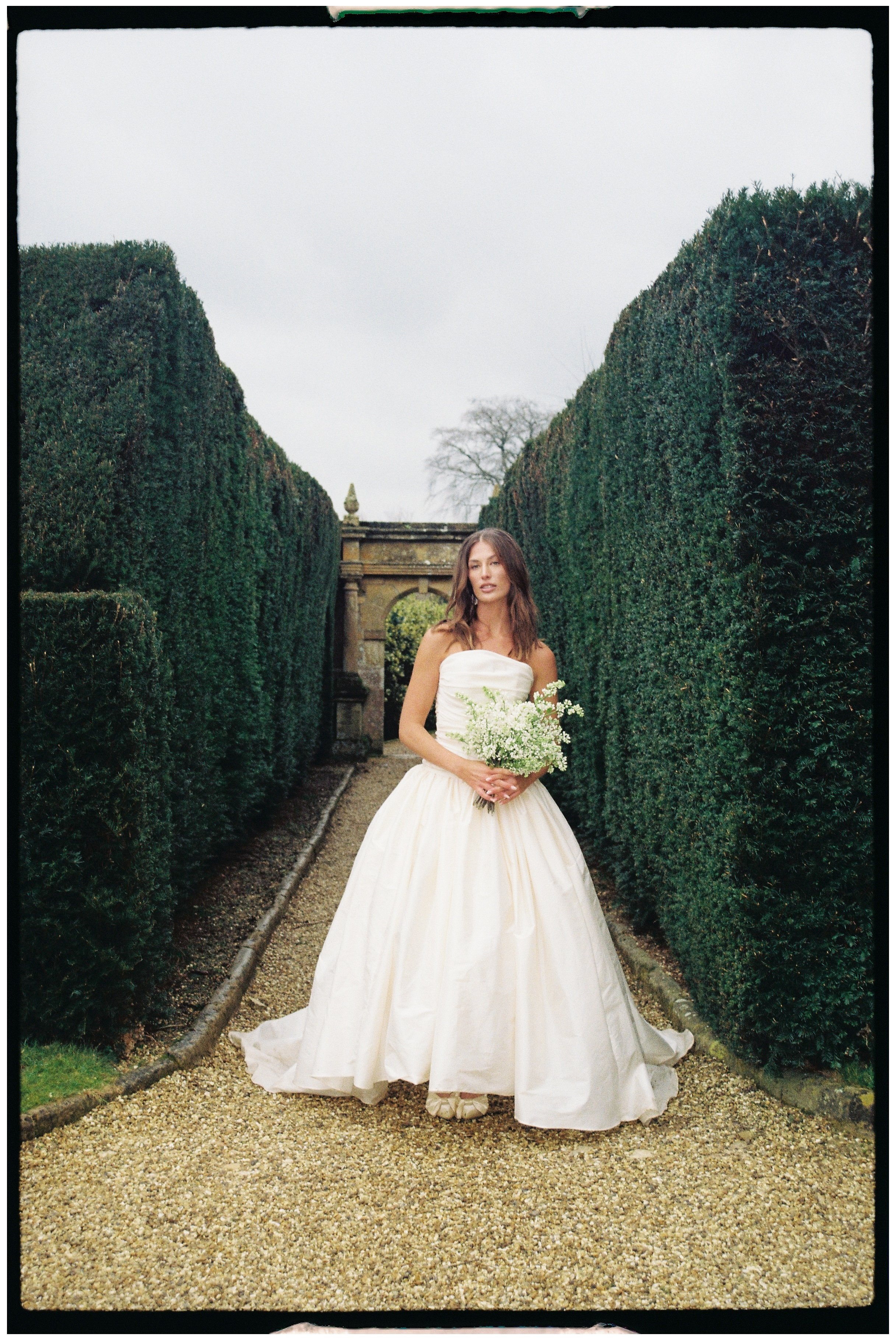 bride stood in the grounds of Sudeley Castle holding onto her bouquet