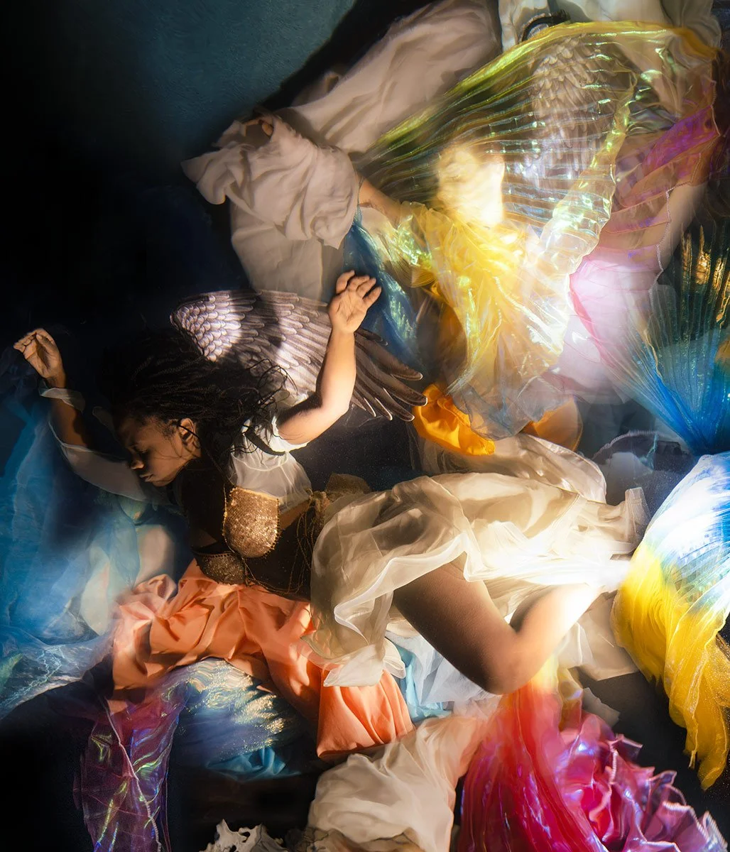 “Myth and Mercy”by Christy Lee Rogers is an underwater photograph from her Myths and Legends collection, depicting multiple figures suspended in an inky abyss.