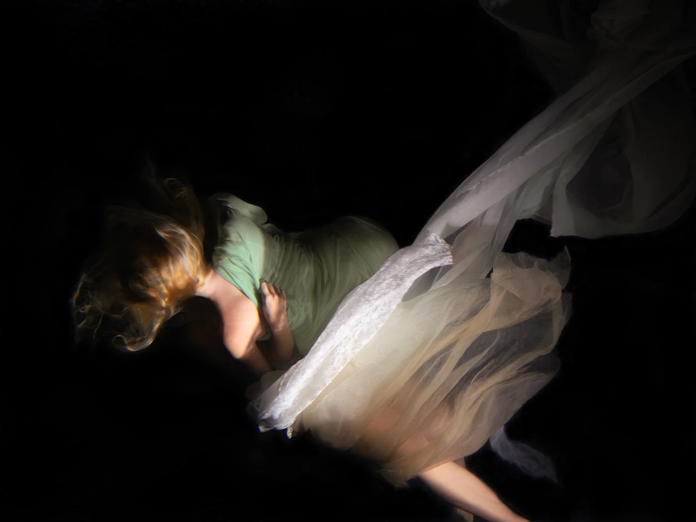 Two figures merge into one beneath the water’s surface, their forms dissolving together in a mysterious, fluid embrace. Christy Lee Rogers uses dark chiaroscuro to heighten the drama.