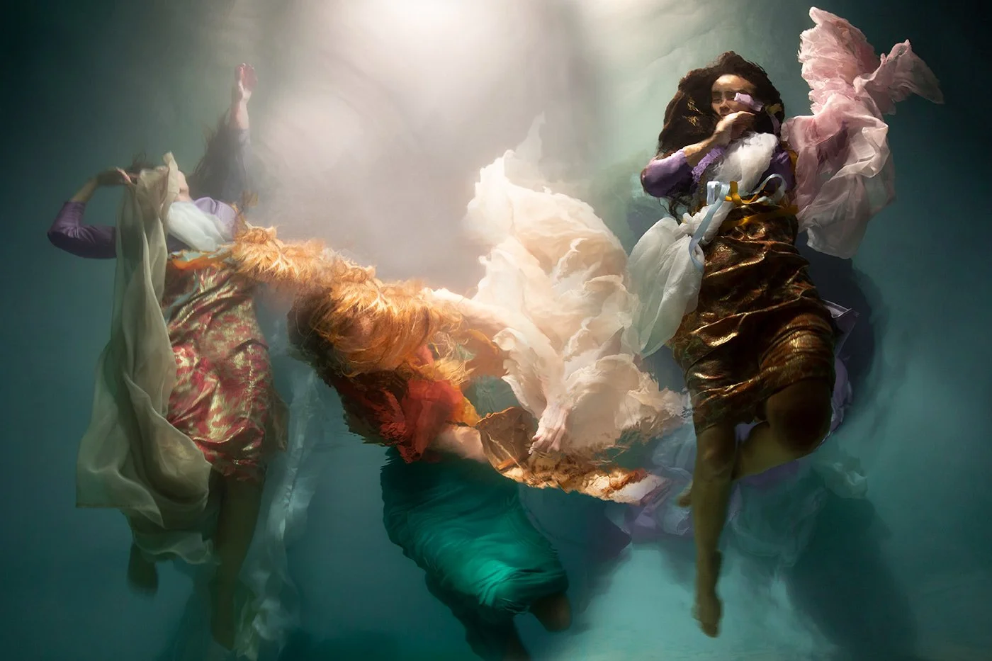 In Flight of Heart, Christy Lee Rogers captures angelic figures drifting upward through water, their bodies wrapped in luminous cascades of fabric.