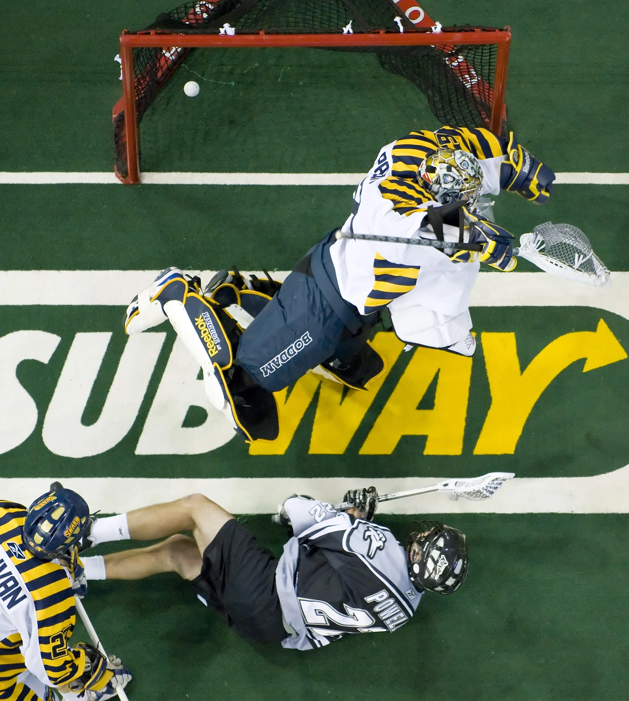  Edmonton - March 27, 2010 - Edmonton's Ryan Powell, #22, dives past Swarm defense Jon Sullivan and scores a goal past Swarm goalie Nick Patterson in a NLL game between the Edmonton Rush and the Minnesota Swarm at Rexall. PHOTO BY JIMMY JEONG 