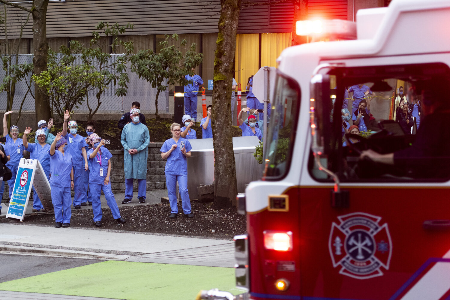  February 26, 2020 - Vancouver, British Columbia - Hospital staff wave as firetrucks and police drive by in a convoy to thank health care workers at VGH. Photo by Jimmy Jeong 