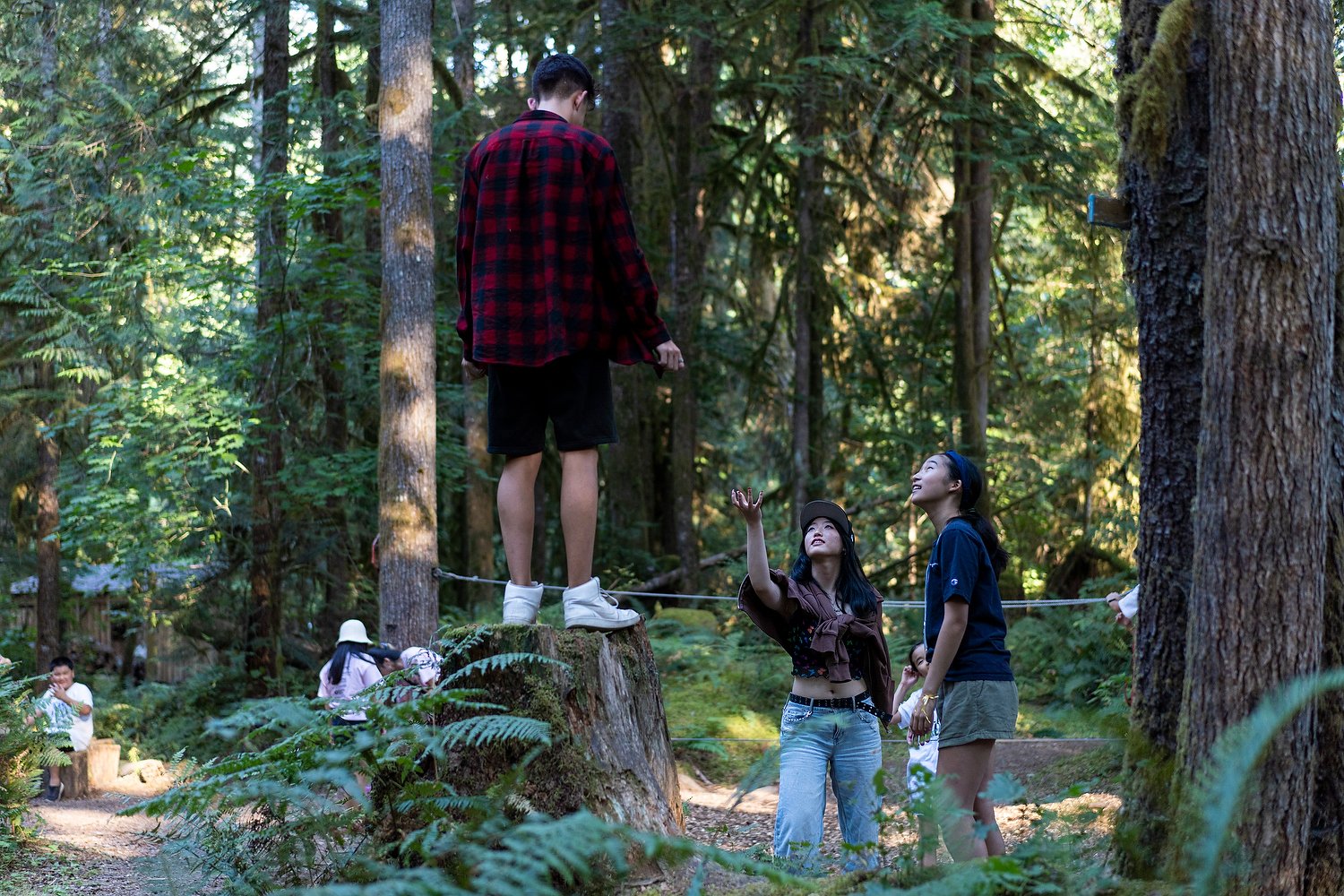  Henry Sarabun, 13, stands on a stump beside Ellie Ahn, 15, and Elizabeth Jung, 14, at Camp Korea, near Squamish, B.C., on September 02, 2022. Started in 2006 by C3 Canadian Korean Society, the four day camp is the only one of its kind geared towards