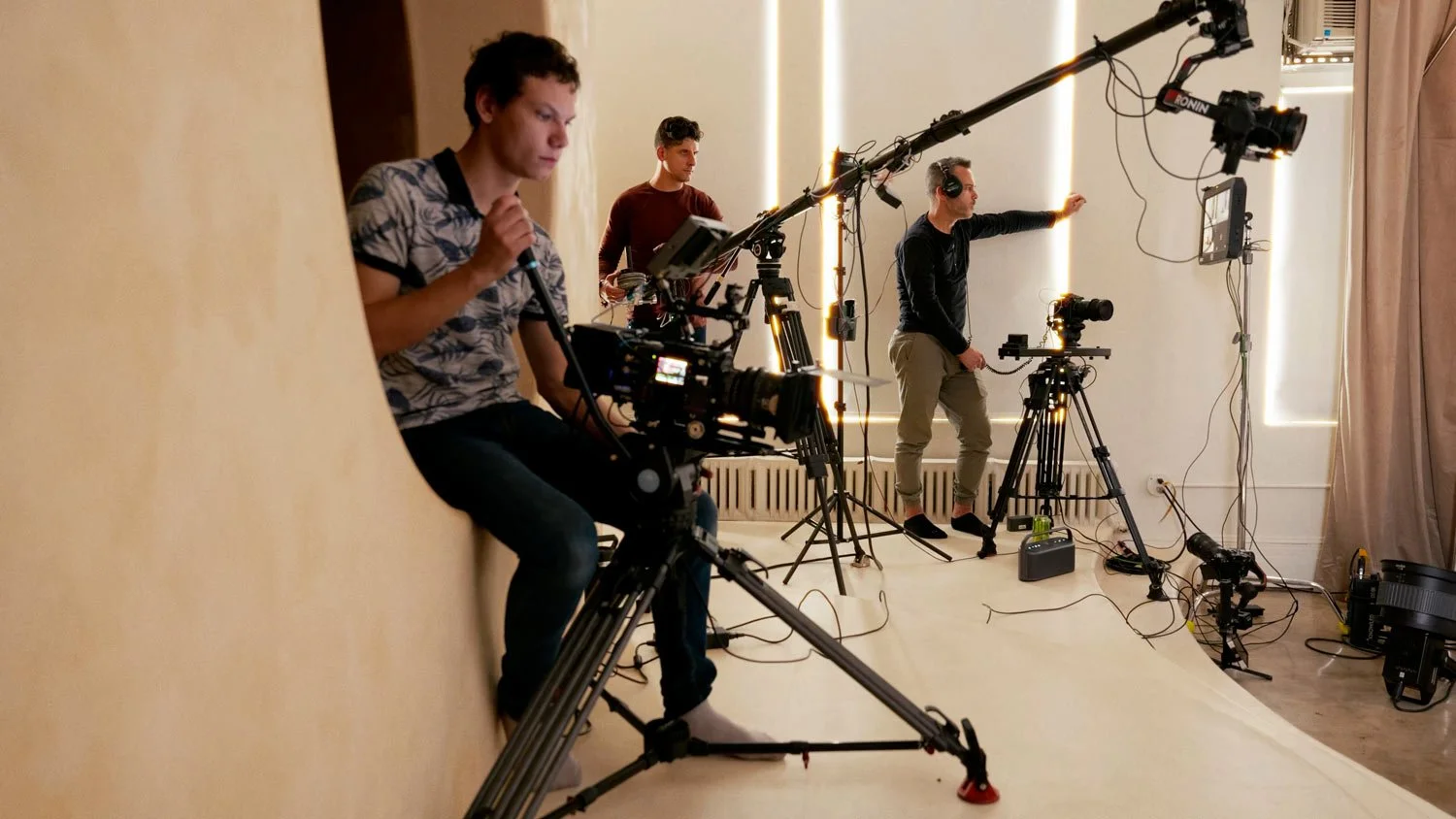 three men on a film set operating cameras