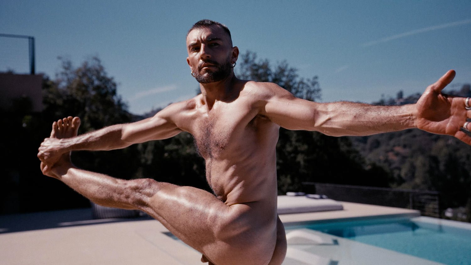 nude yogi doing extended hand-to-big-toe pose outside