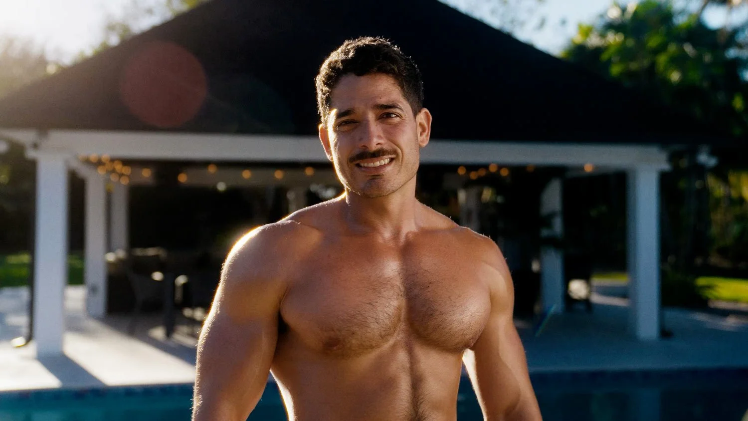 smiling muscular oiled man looking at camera