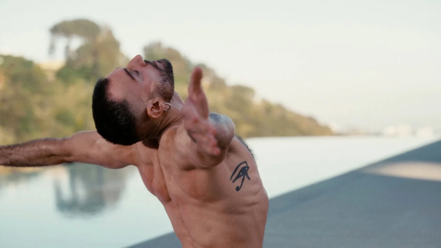 shirtless man leaning back with his arms extended out