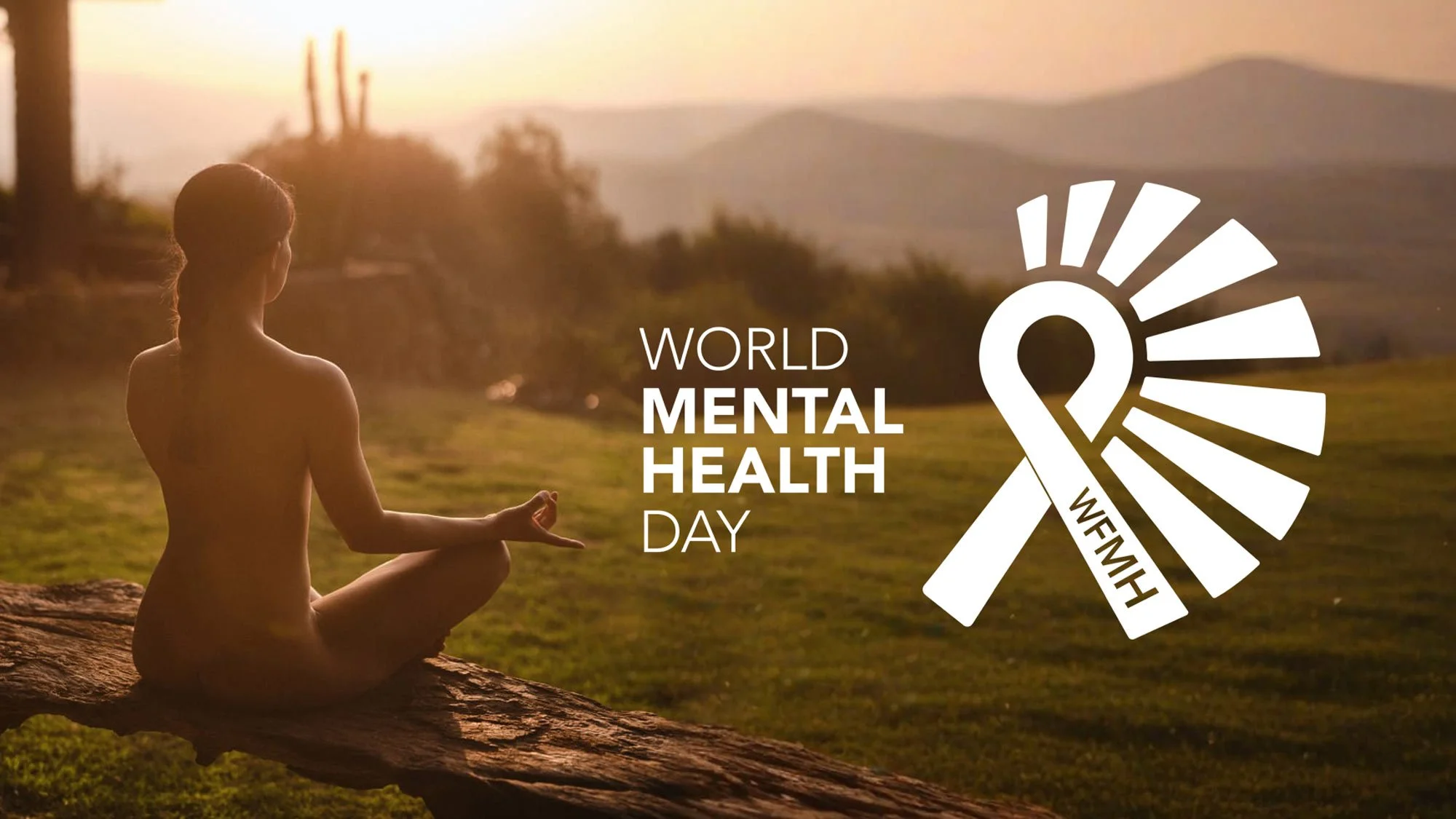 naked woman meditating outside at sunset with lush green grass and mountains