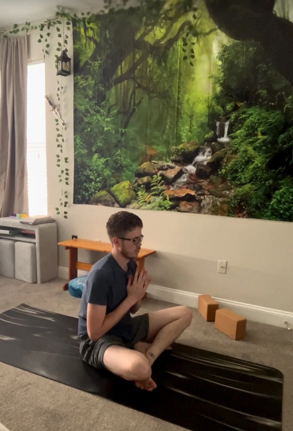 Man sitting crossed legged and hands in prayer practicing yoga