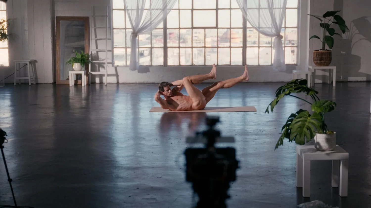 naked man on yoga mat working out doing bicycle crunches