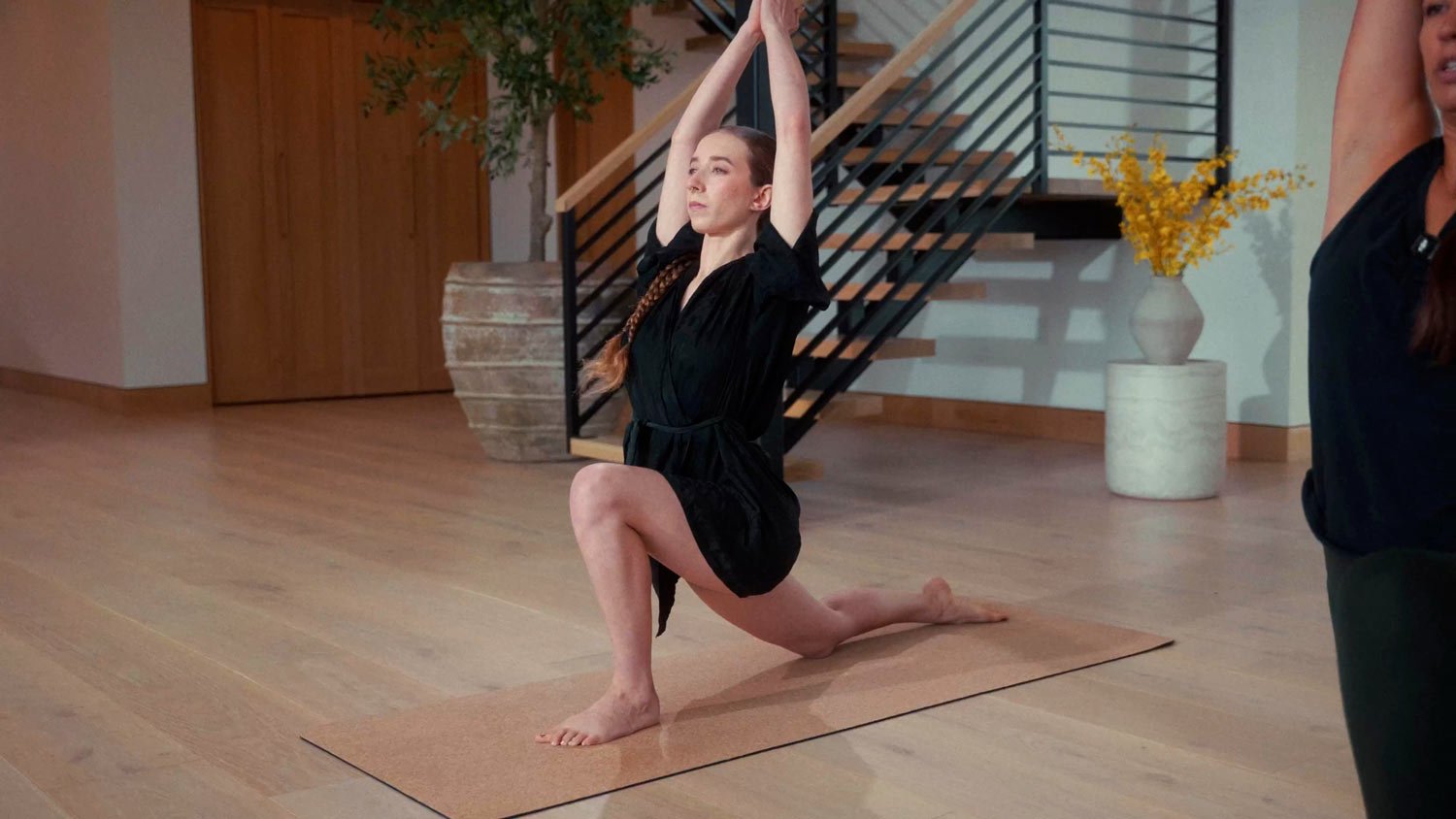 woman in robe on yoga mat in low lunge pose