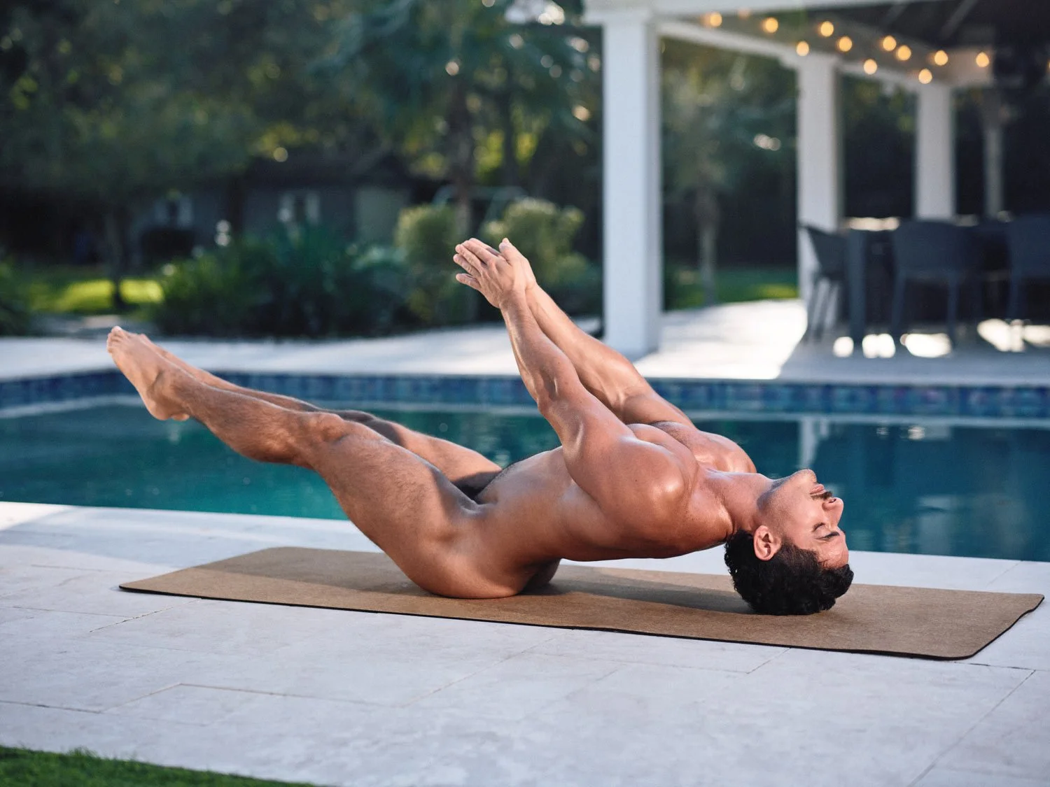 nude man doing naked yoga in raised legs pose