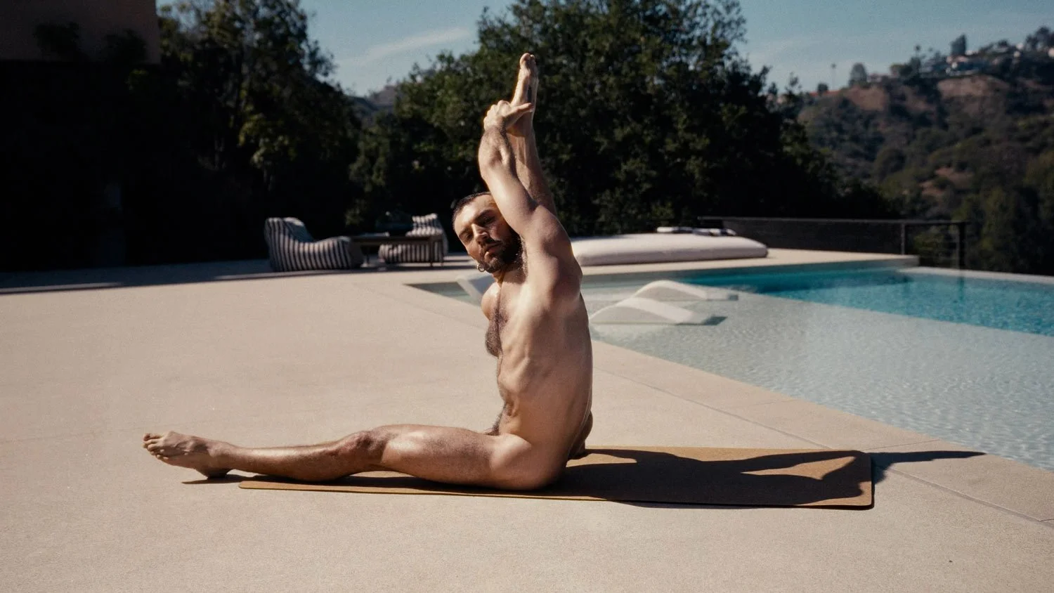 nude man poolside in compass pose