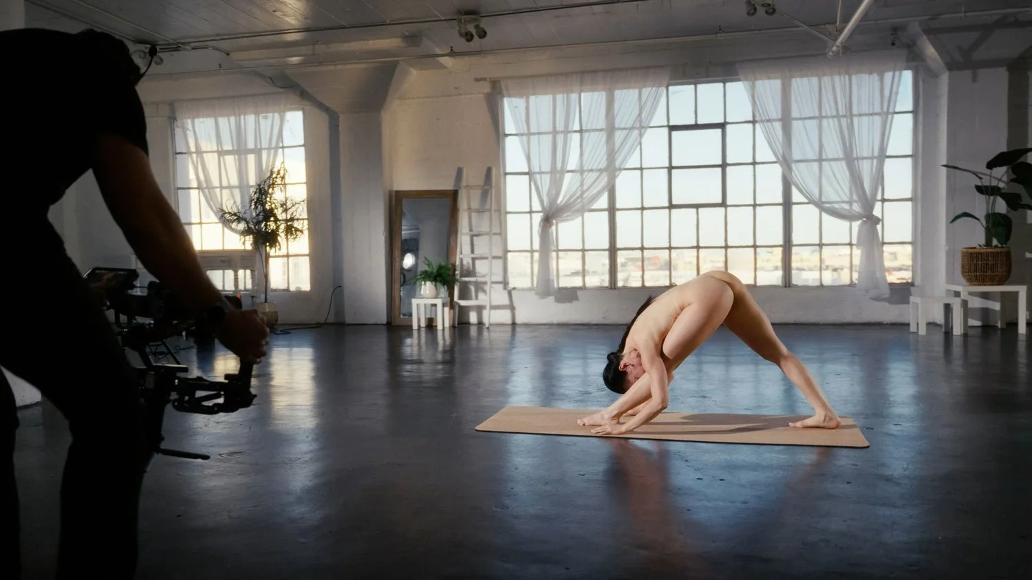 behind-the-scenes on a naked yoga shoot with woman in pyramid pose