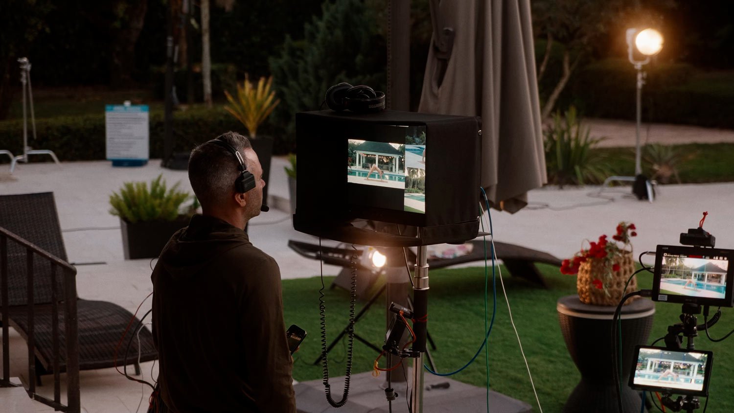 man standing on set viewing the monitors of a naked yoga shoot
