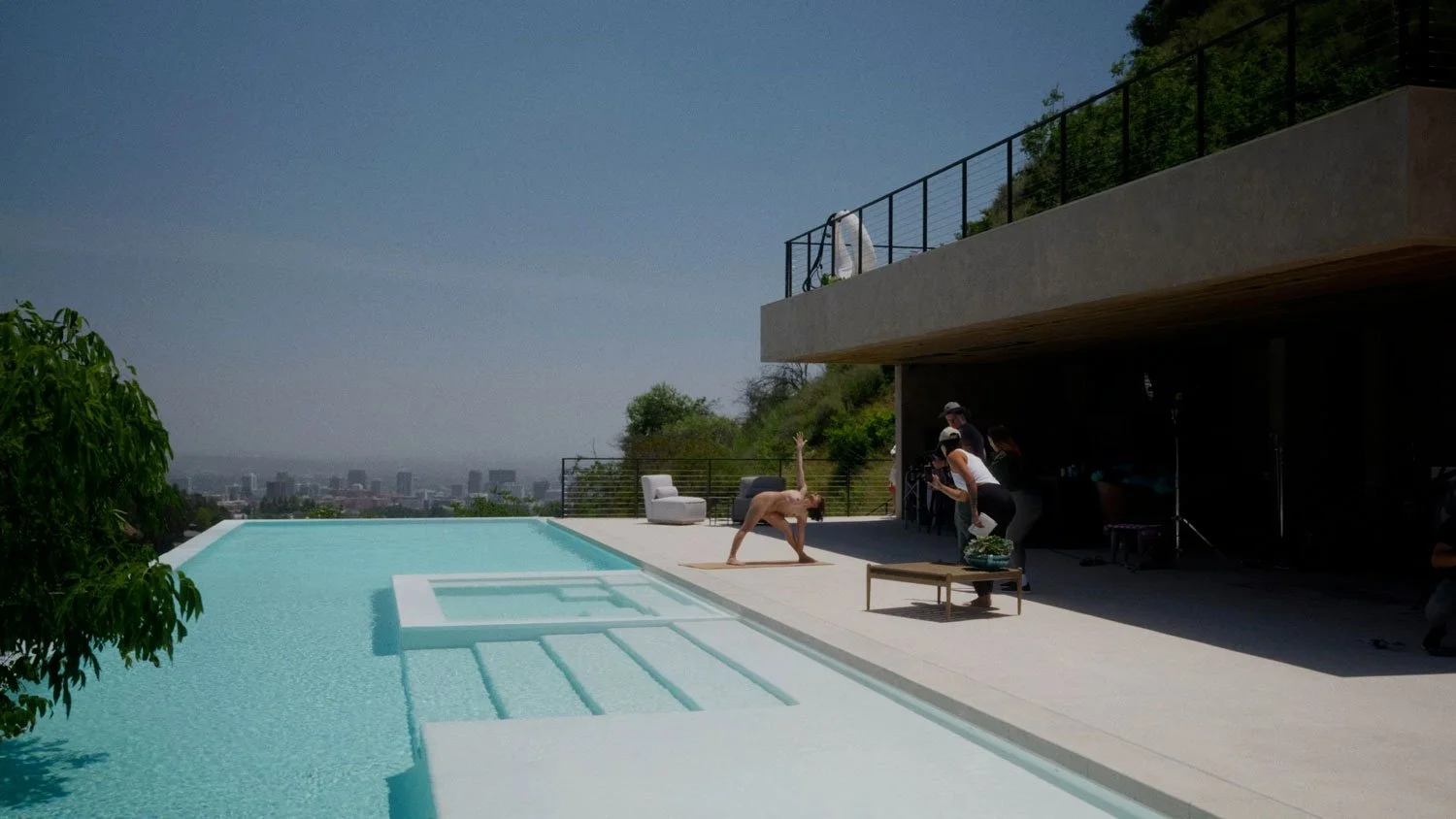 woman practicing nude yoga by a pool