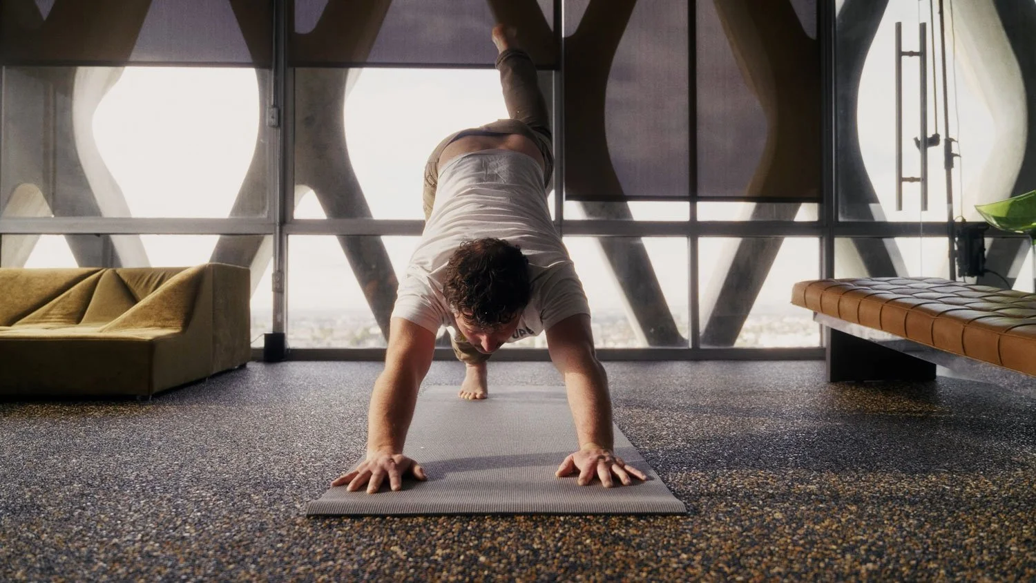 man doing yoga in three legged dog pose