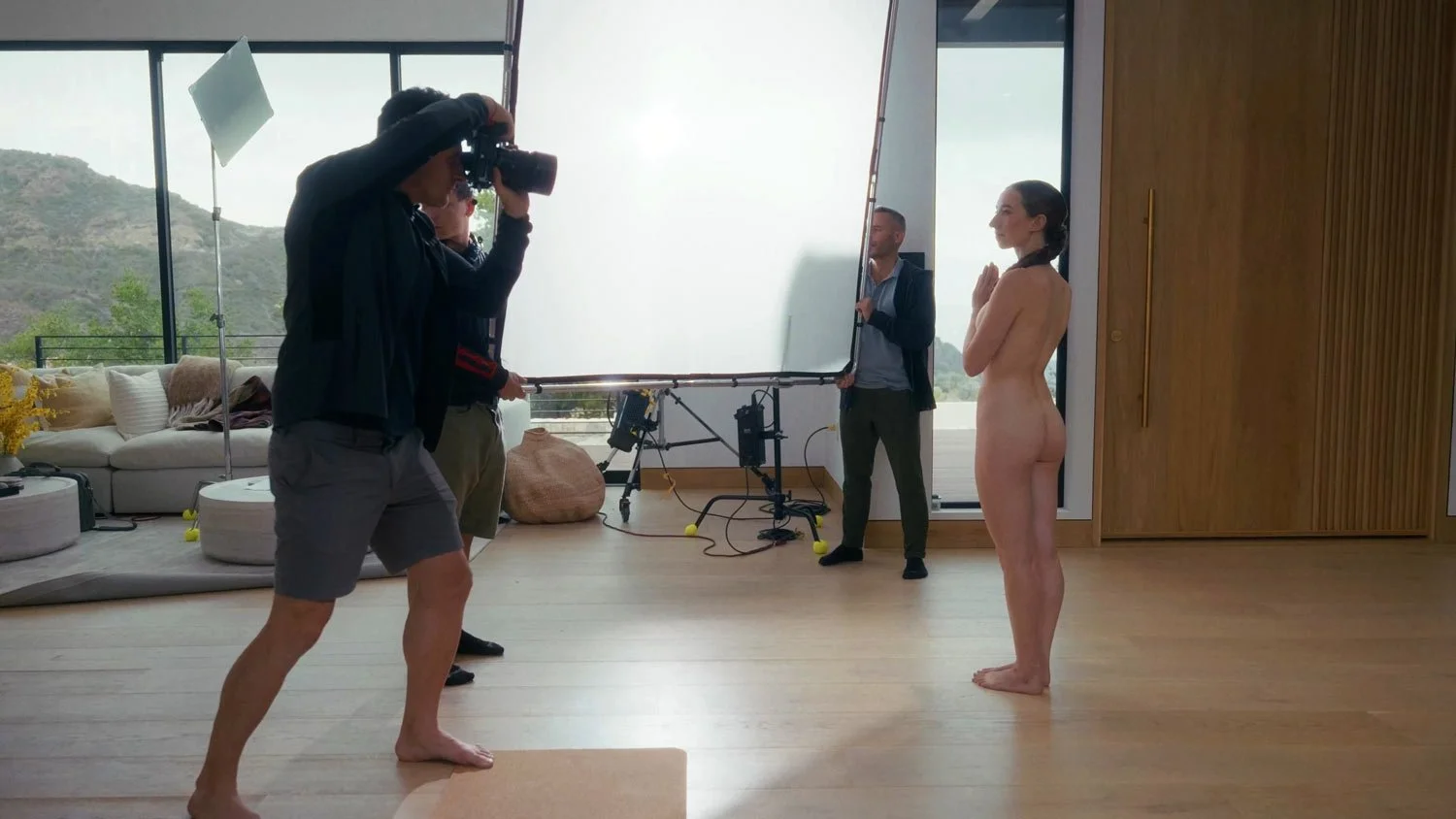 naked woman getting her photo taken with her hands in prayer pose