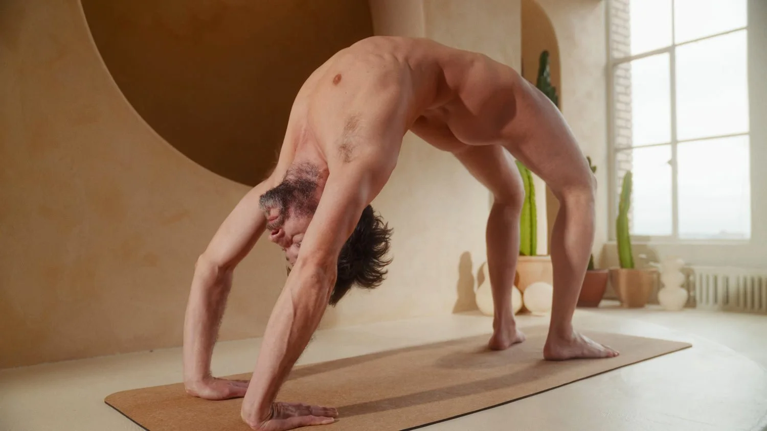 naked man in full wheel pose