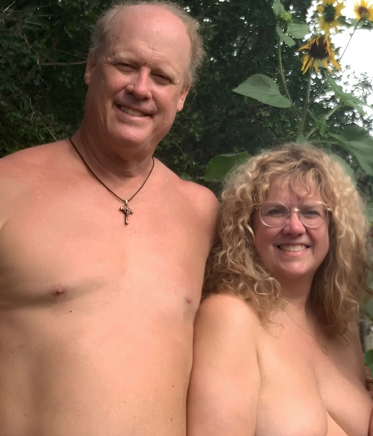 naked couple with arms around each other outside