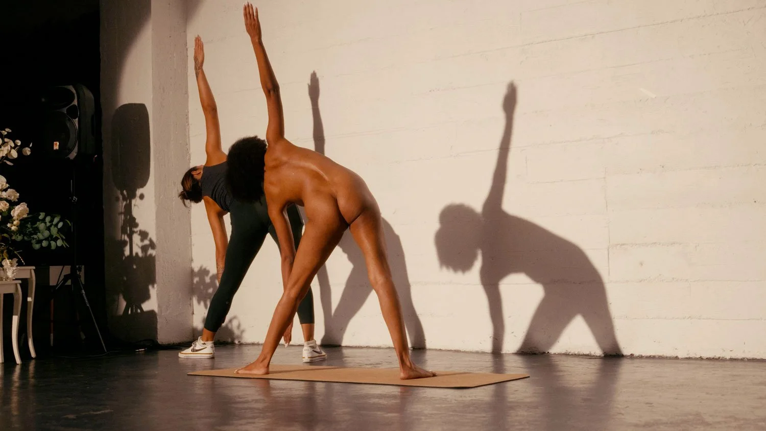 nude woman learning yoga in triangle pose