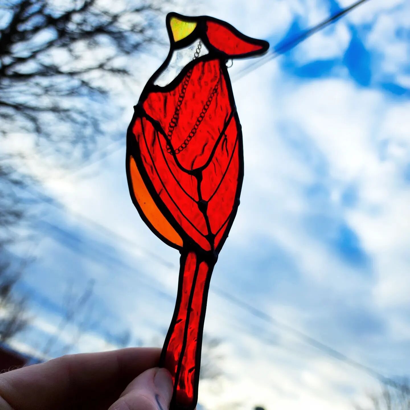 This was a special request, and I'm so pleased with how it came out!

I wanted to design a cardinal that showed both wings, so I used an 18/20g copper wire suspended over the glass to do this. 
This way, the red glass is one solid piece and lets so m