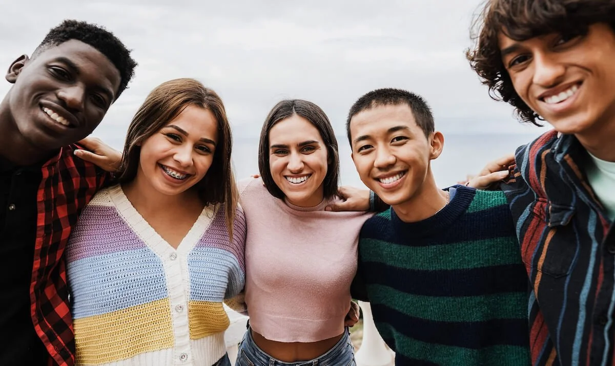 diverse group of teens smiling at the camera
