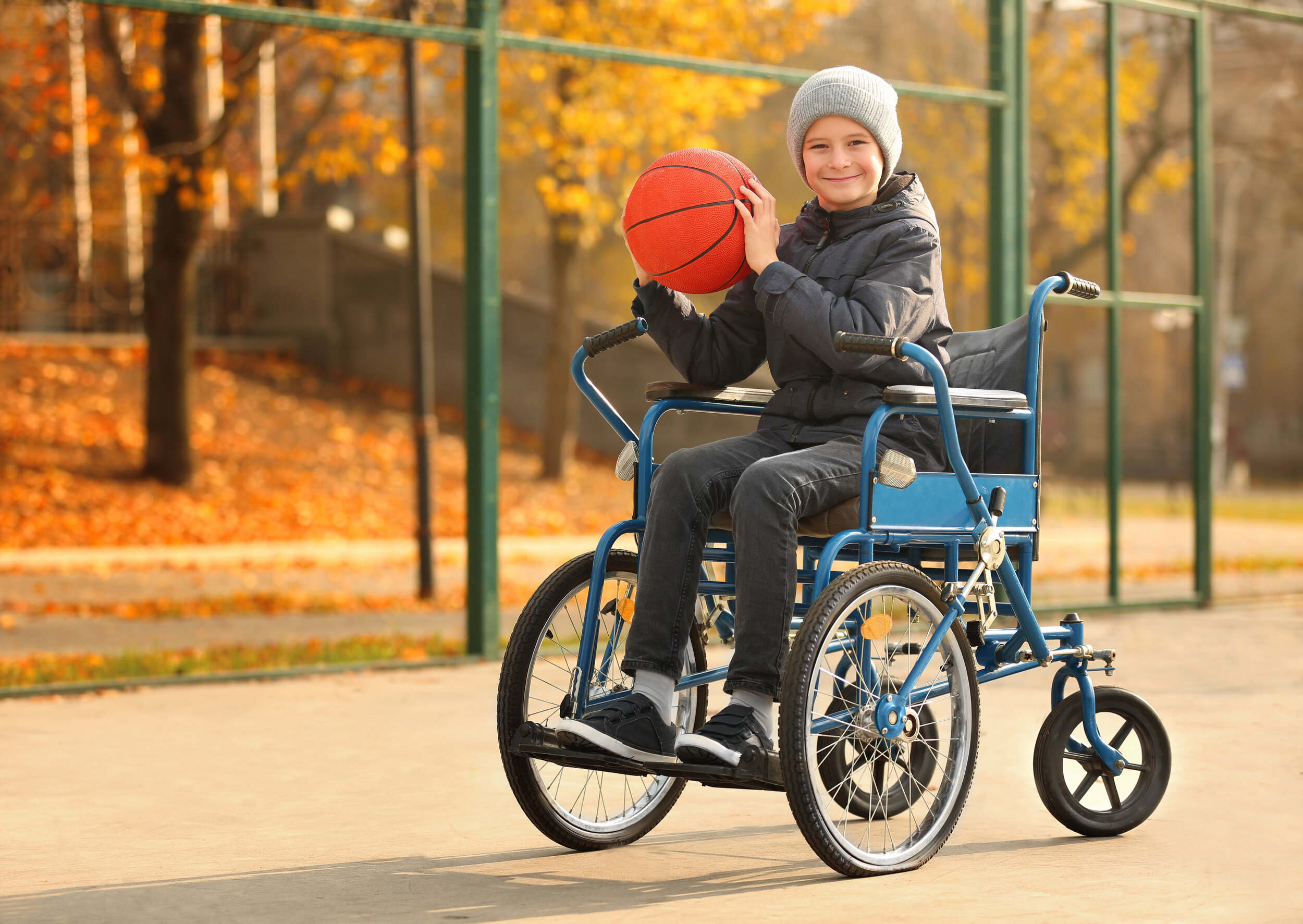boy in wheelchair holding basketball