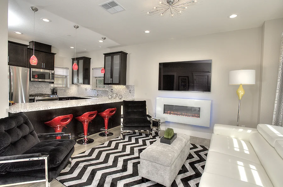 Modern living room with three red chairs and a black and white floor mattress and television